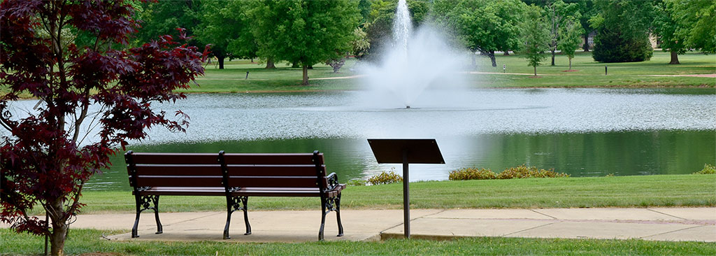 A park bench in front of Legacy Lake