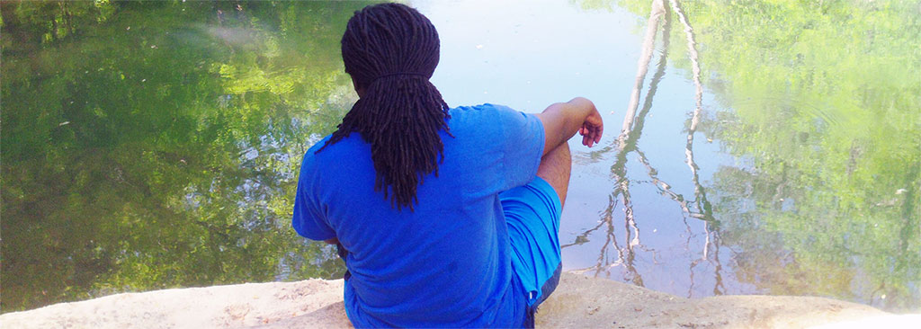 A student sits at the water's edge