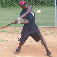 An intramural baseball player swings at a pitch
