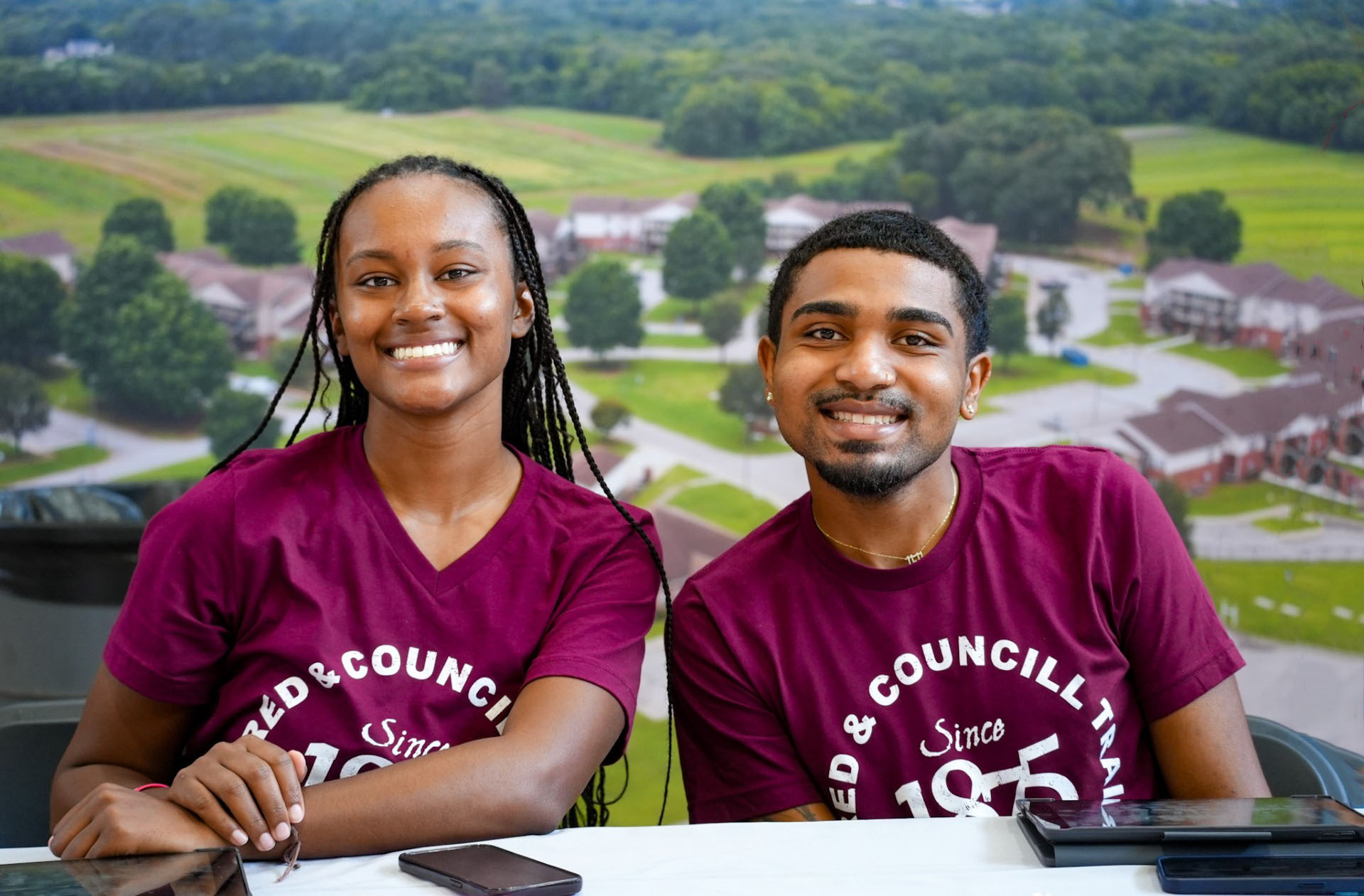 Two students seated at a help desk at the start of the fall semester