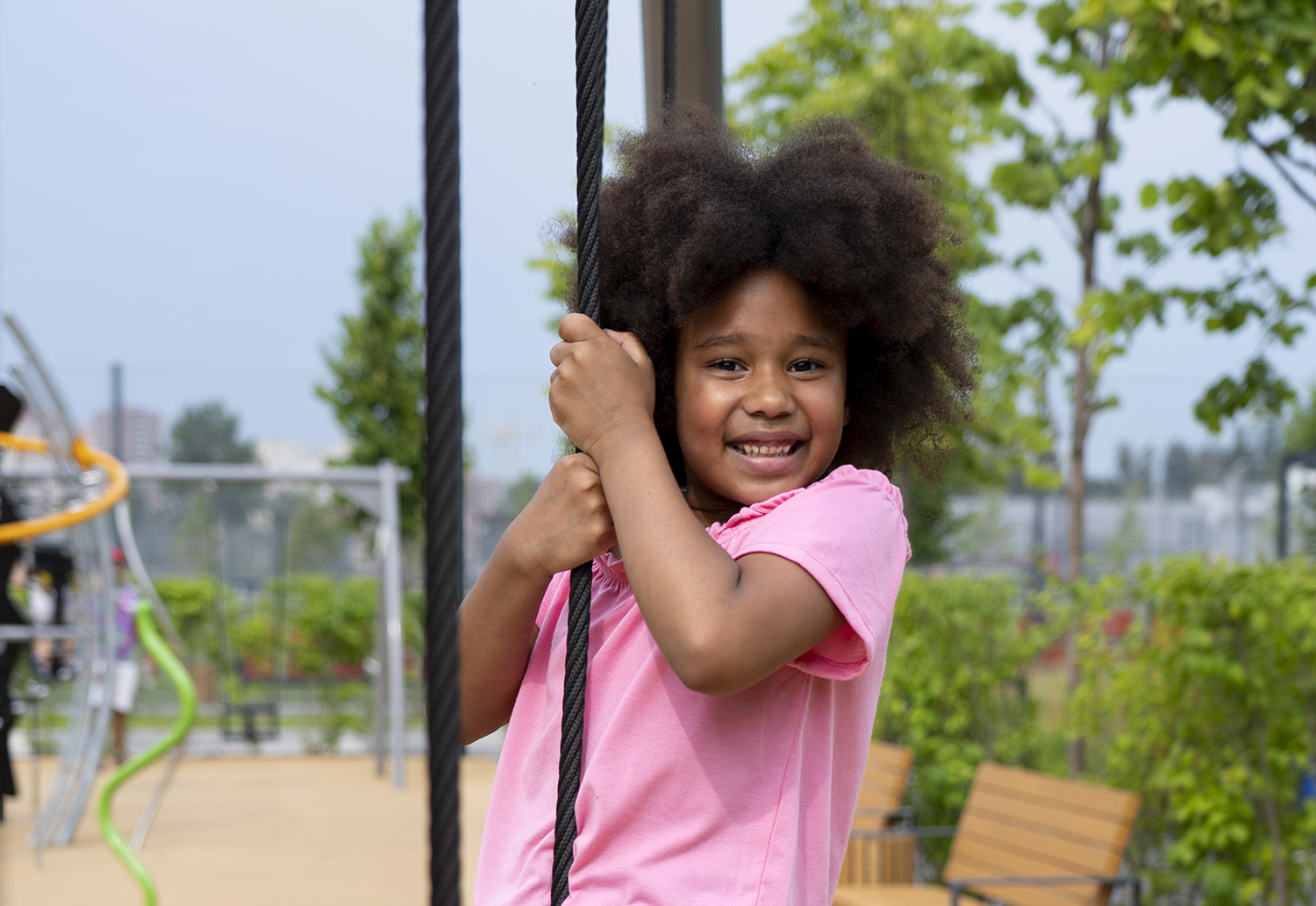 Child smiling on rope swing.