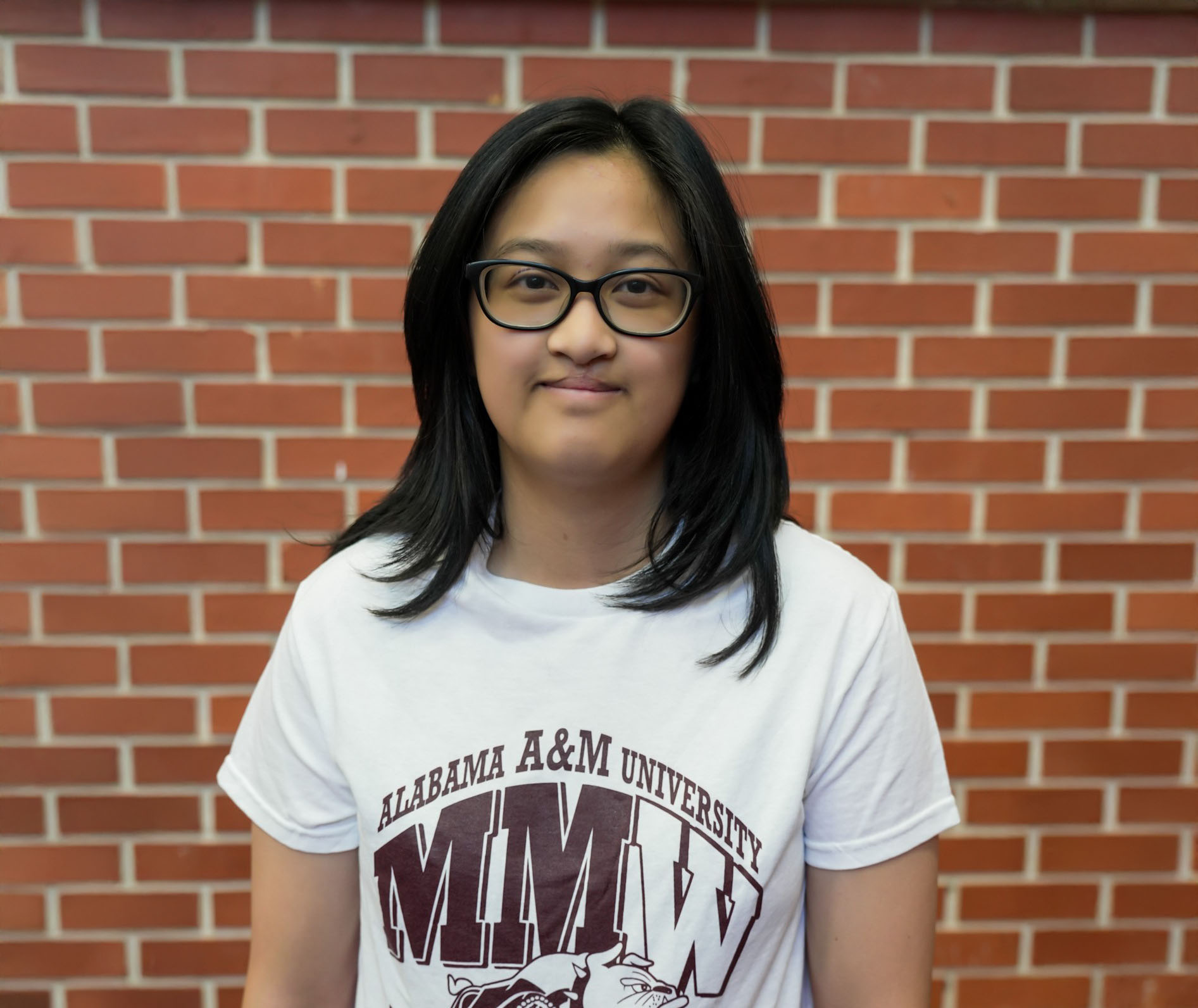 Aliya Khanthavong smiles at camera in MMW rehearsal room in the Morrison Fine Arts building on campus