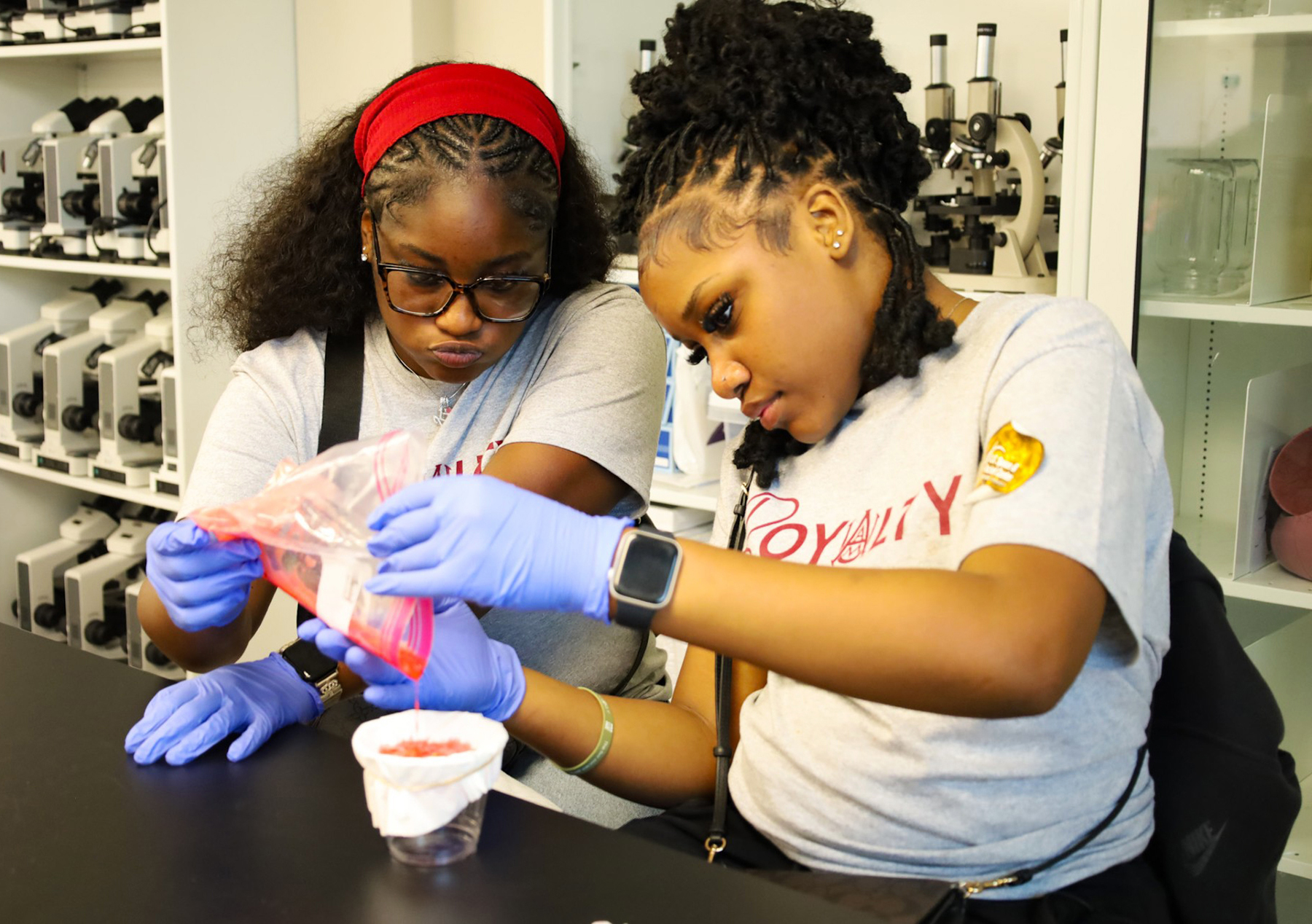 Two students extract DNA from strawberries and explore chromosome simulation during a laboratory activity led by Dr. Wayne Kennedy and instructor Bria White.