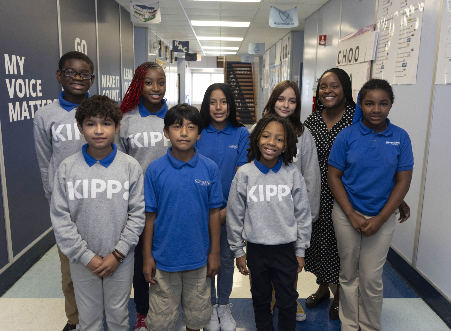 Camille Allen in the back right smiles with seven of her students at Kipp Academy Chicago