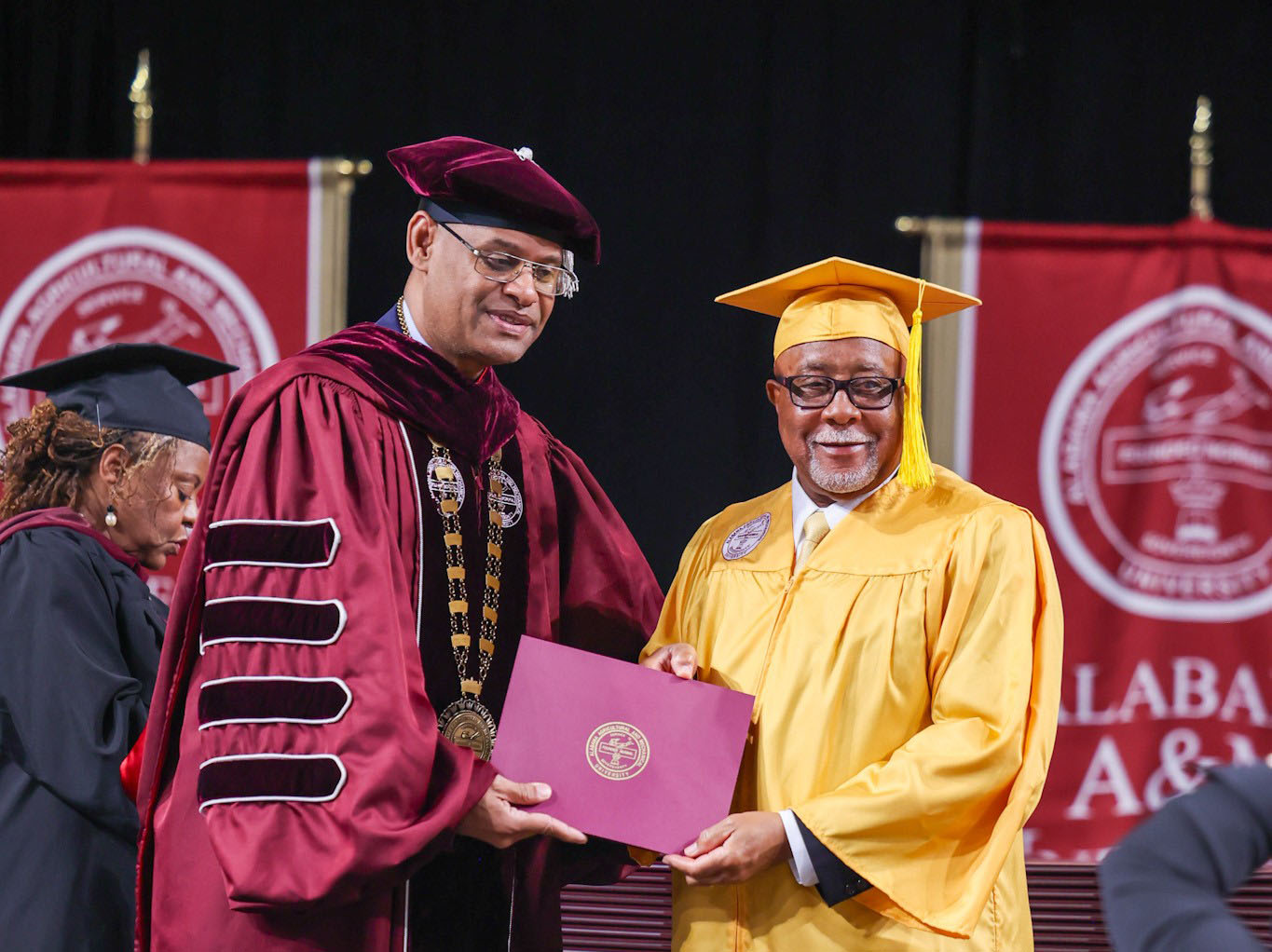 President Daniel K. Wims gives Charles Barnes his Golden Class of 1974 certificate during the Spring 2024 Commencement