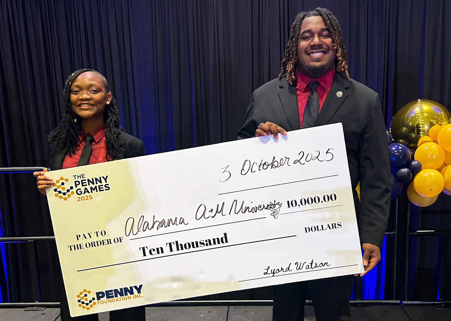 Miracle Olatunji and Chance Williams hold $10,000 check after winning the 2025 Penny Games