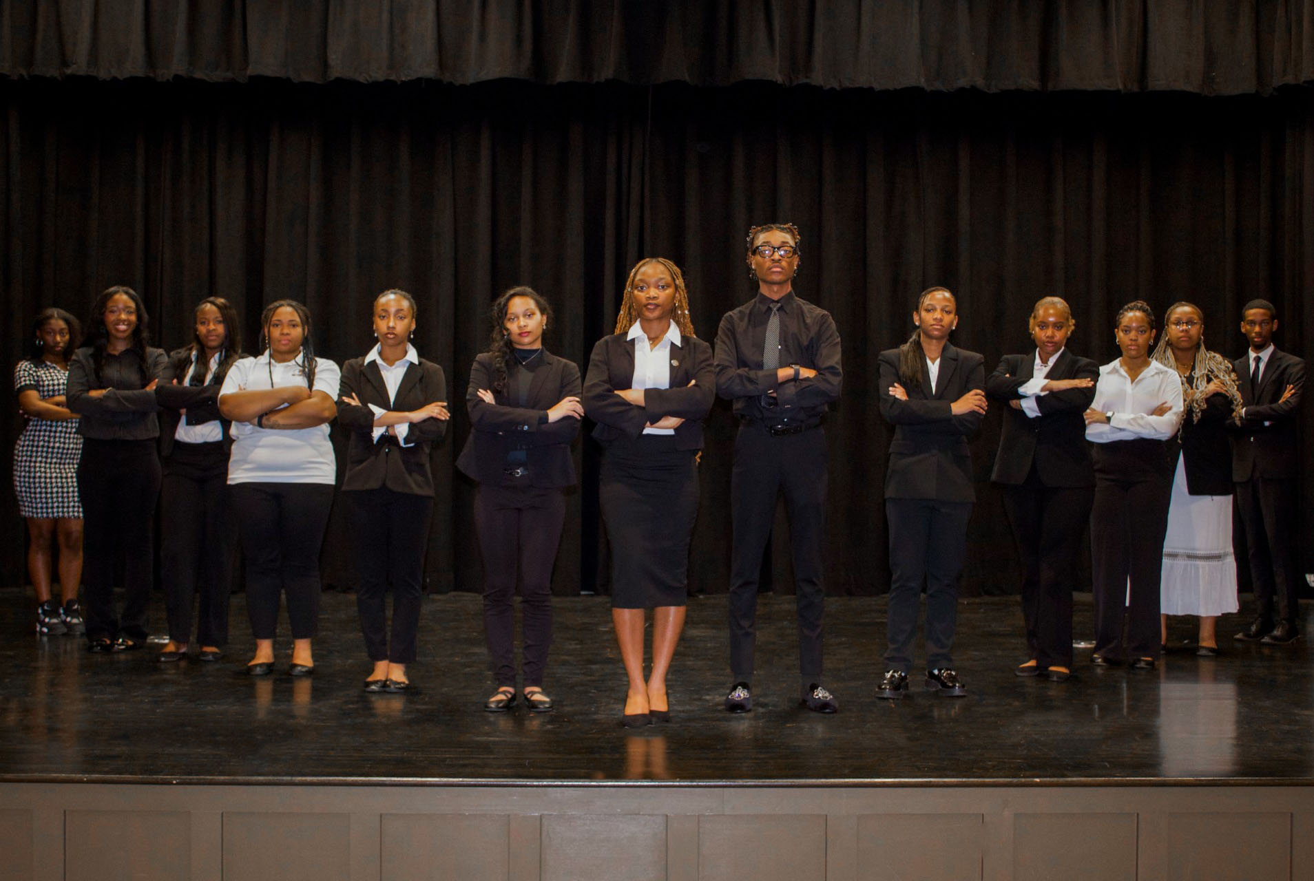 (Photo L-R) Katelyn Whitley, Lydia Kennemer, Jarah Waldon, Alivia Morris, Karizma Harris, Shyla Wade, Miracle Olatunji, Quavion Sims, GeKhiya Brown, Rae Bell, Monica Williams, Shanel White, Kelvin Edwards standing on stage in Bradford Auditorium in Buchanan Hall