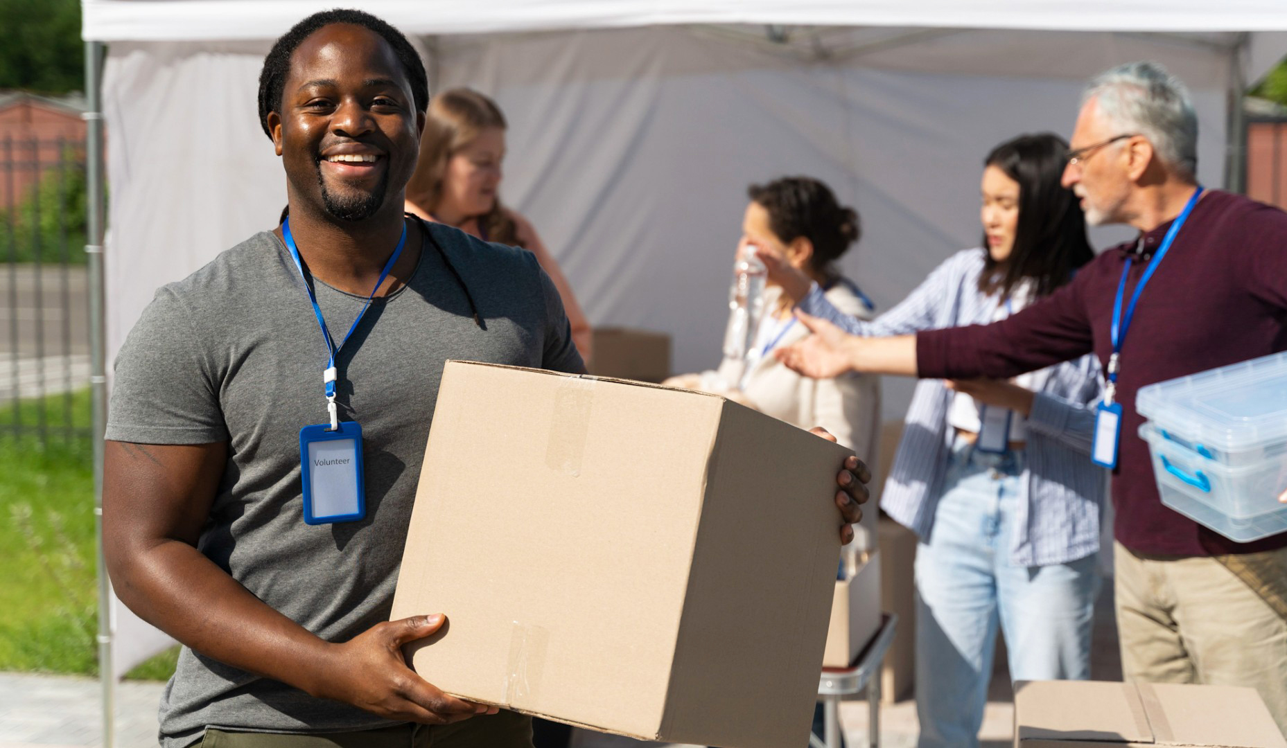 Volunteer holds box of food with four volunteers behind him