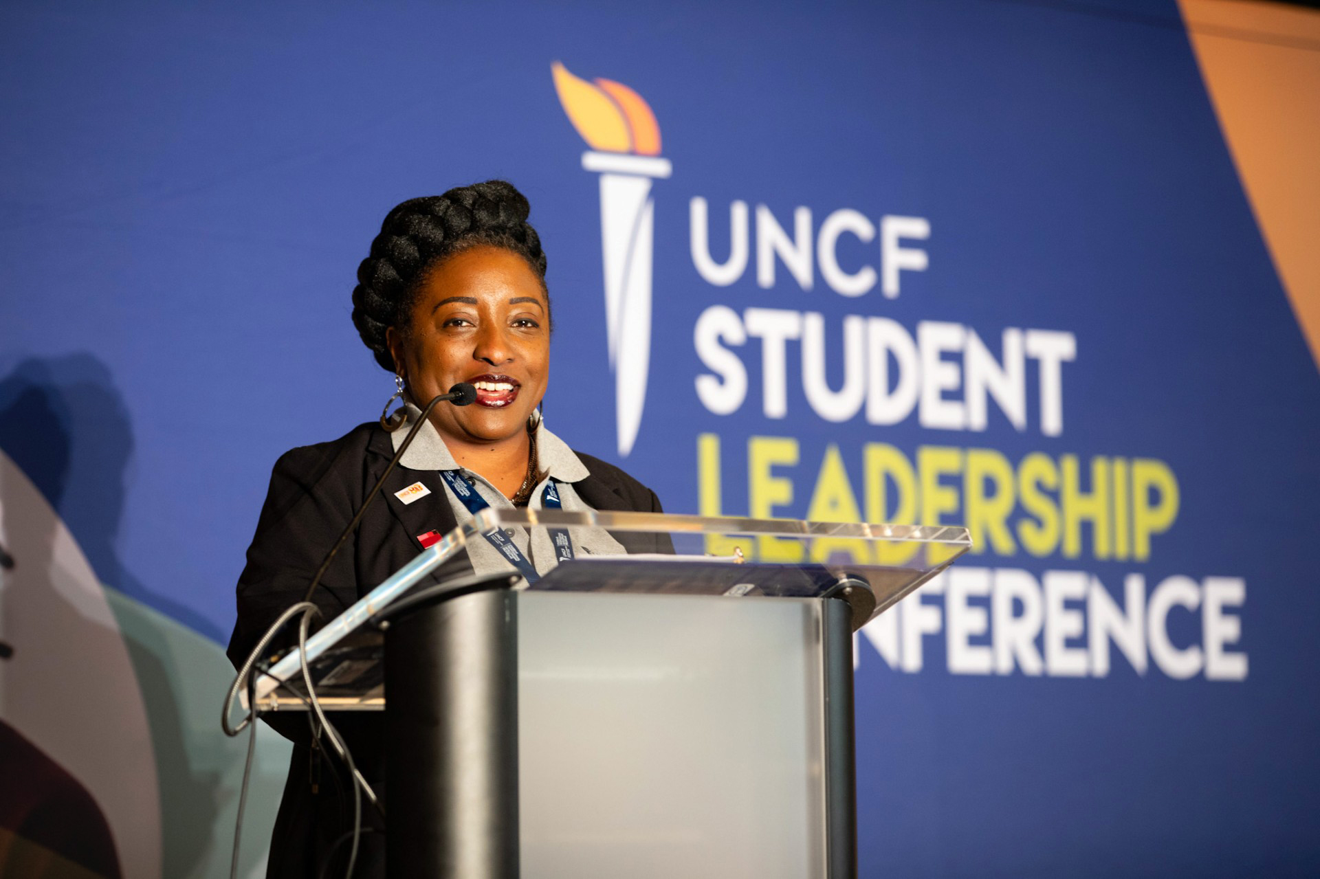Taliah Givens speaking at a podium on stage during recent UNCF event