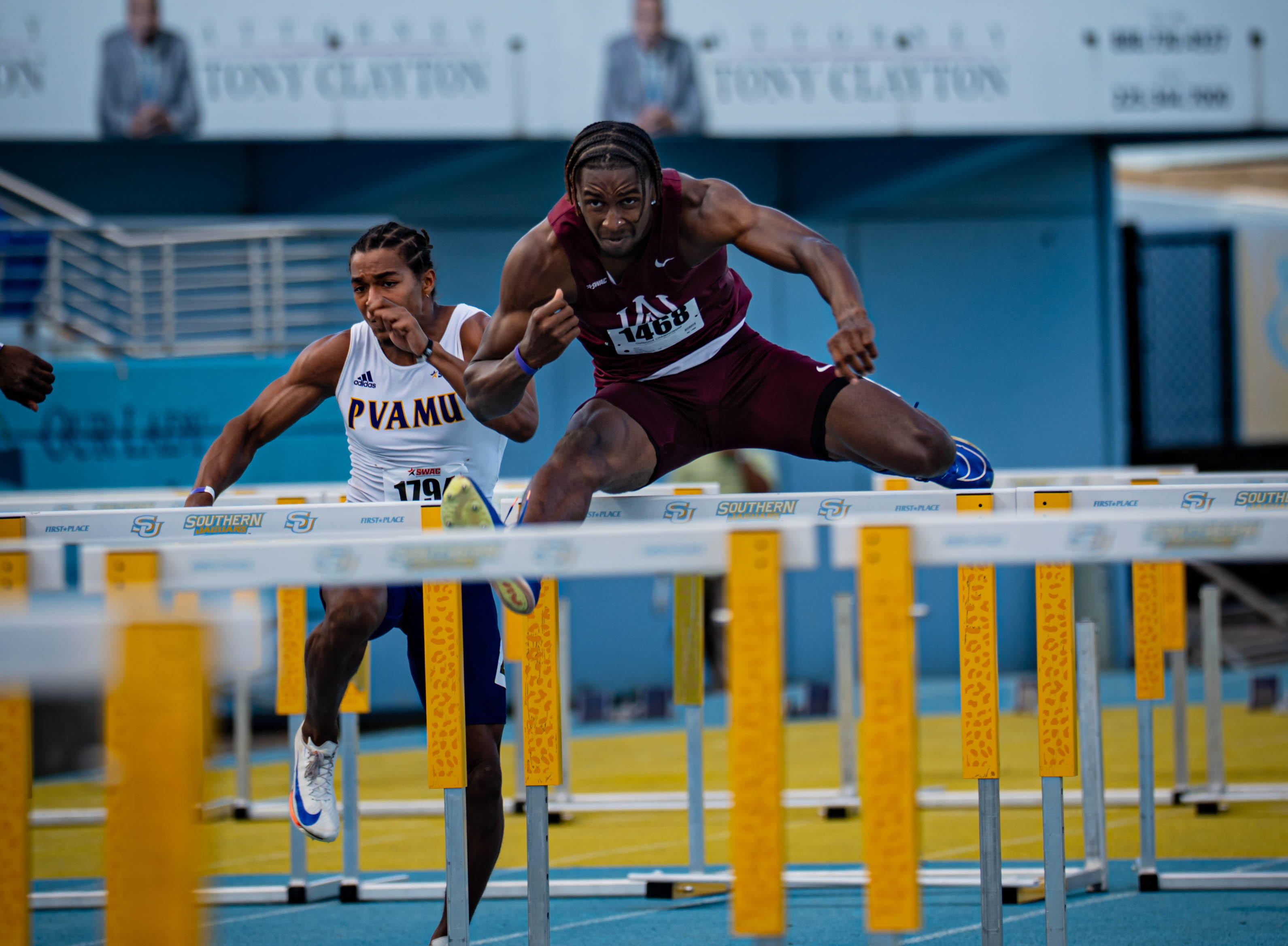 Eric Barker jumps a hurdle in a recent race with a hurdler from Prairie View A&M behind him