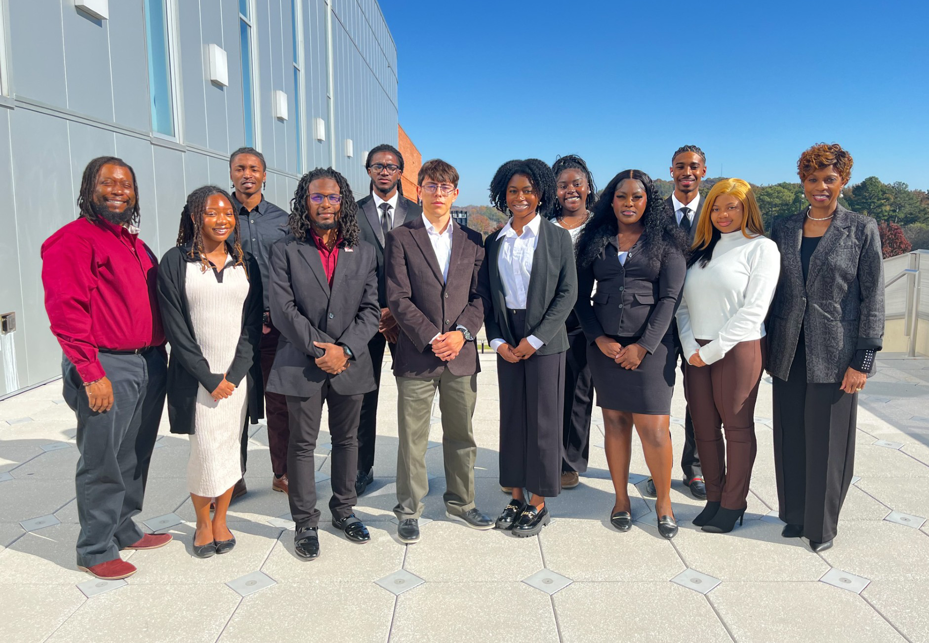 Dr. Ed Pearson III, Schylar Robertson, Jason Bledsoe, Jeremiah Provost, Timothy Smith III, Juan Osoria, Ogechukwu Amah, Kortney Adkins, Ariel Graham, Jay Mayes Jr., Madison Starnes, Sonya Merritt stand outside on the second floor of the AAMU Event Center