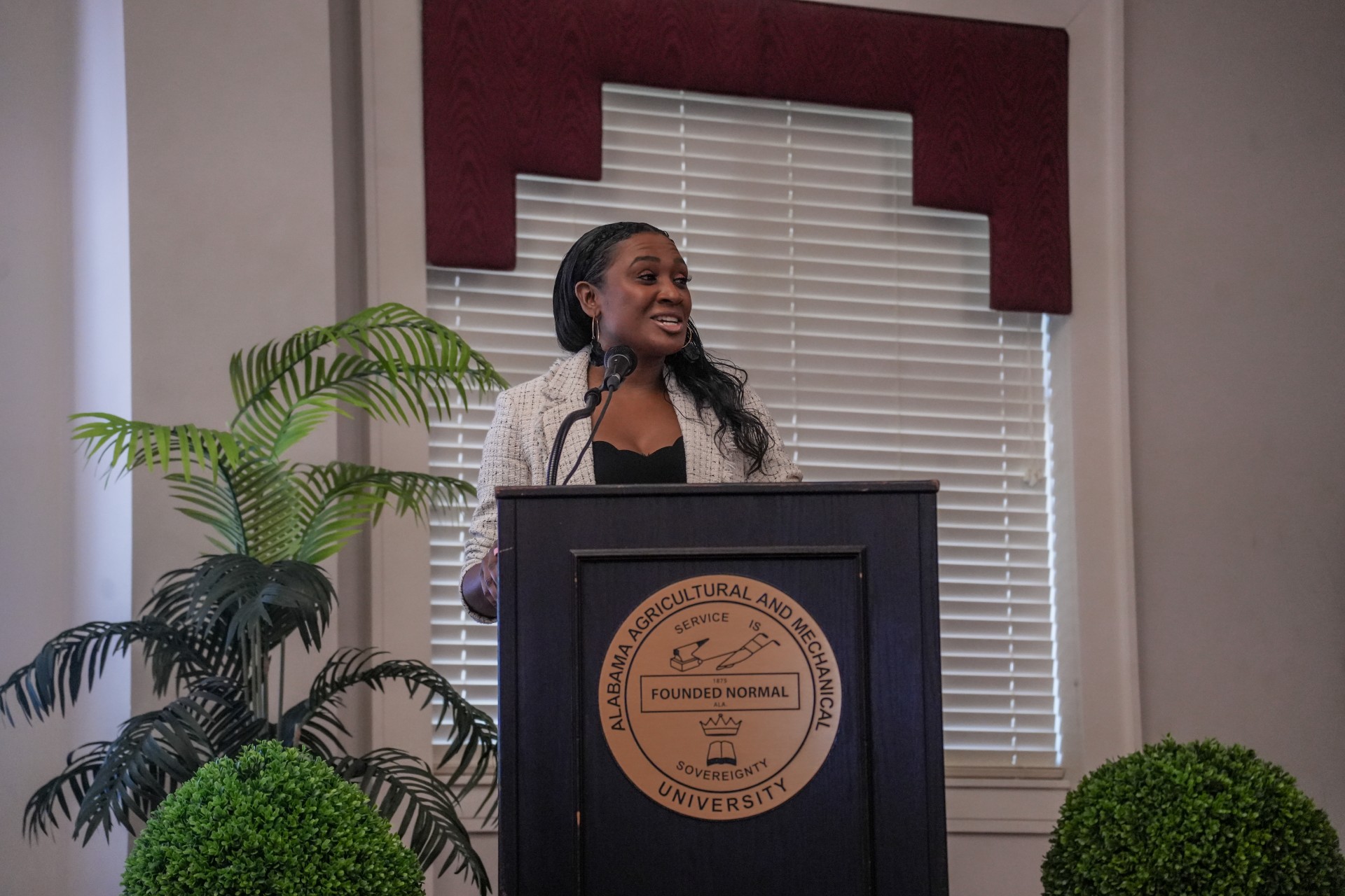 Dr. Tashni-Ann Dubroy at podium at International Women's Day Celebration in the Knight Center