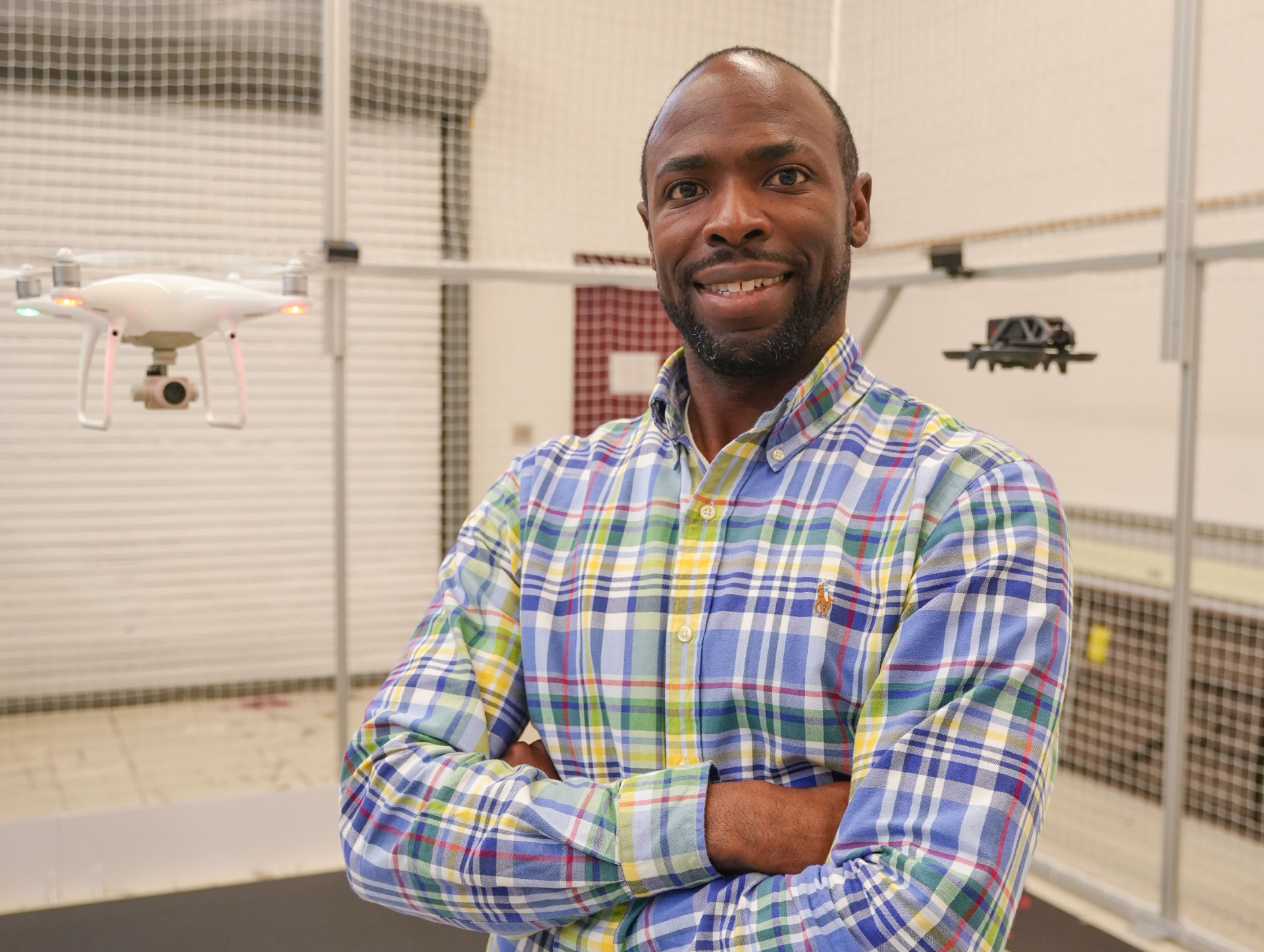 Justin Vaughne in AAMU's state-of-the-art AI Cave with two drones flying beside him 