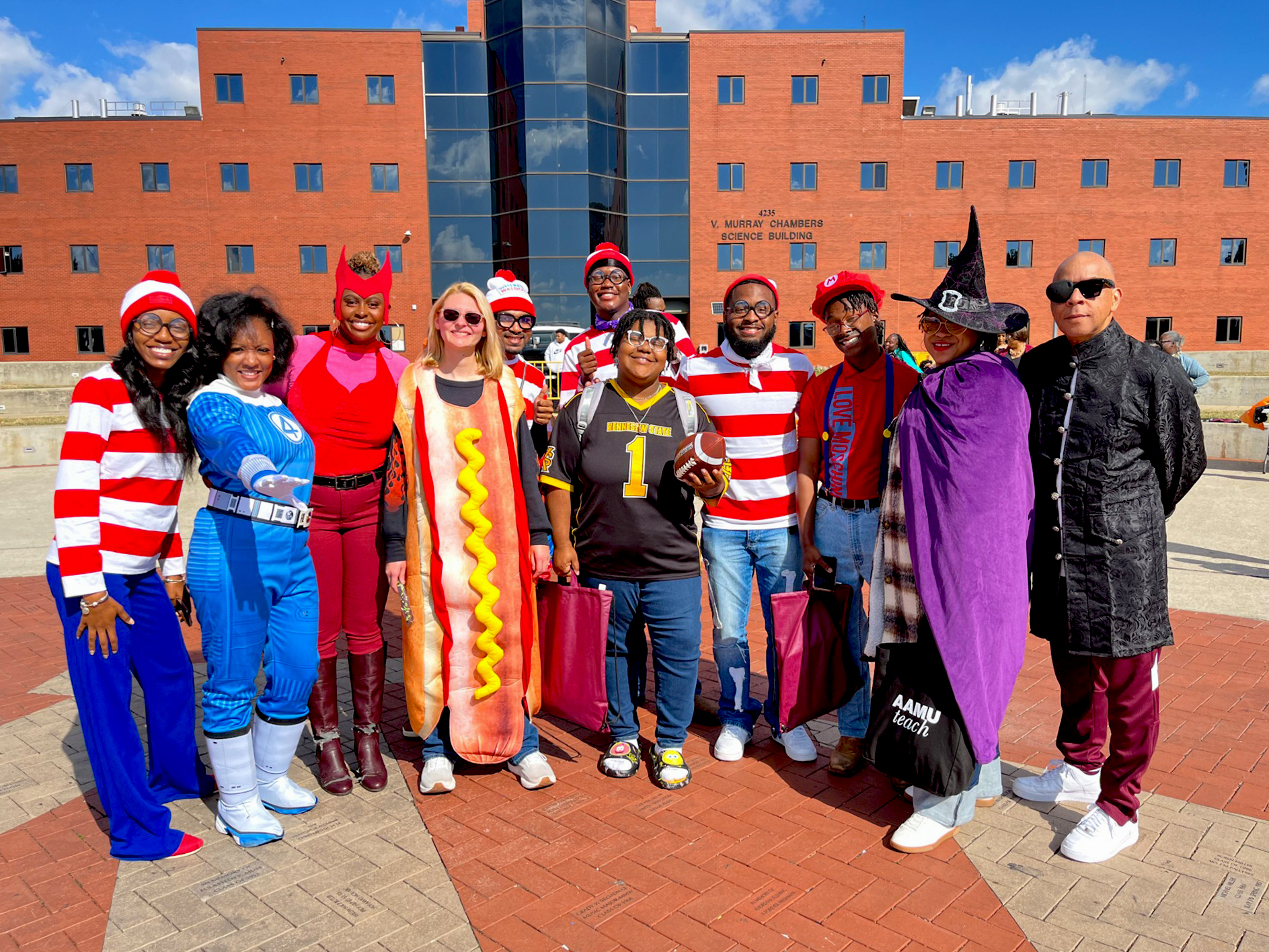 Group of AAMU students, administrators and faculty dressed in Halloween costumes pose for a photo on The Quad