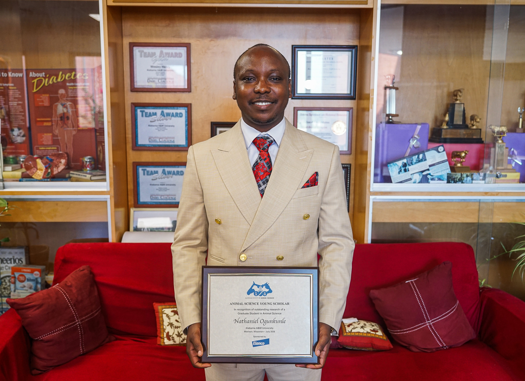 Dr. Nathaniel Ogunkunle holds his ASAS Young Scholar Award in the Carver Complex on the AAMU campus.