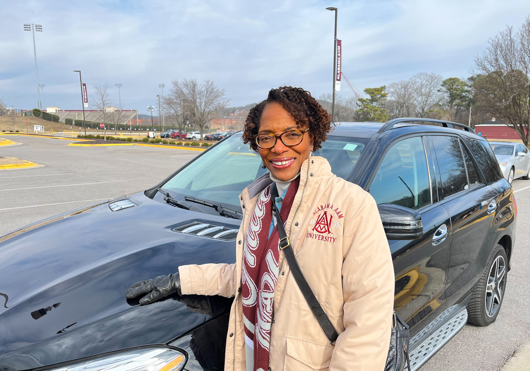 AAMU Alumna Claudinette Purifoy-Fears stands in front of her current car, not the one she donated, in the AAMU Event Center parking lot 