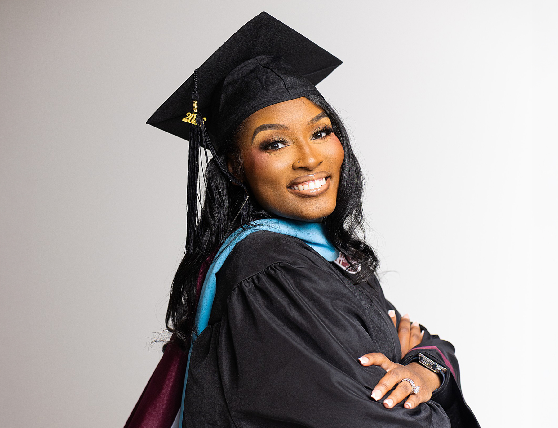 AAMU graduate student Keunna Goode smiles while wearing her cap, gown and academic hood