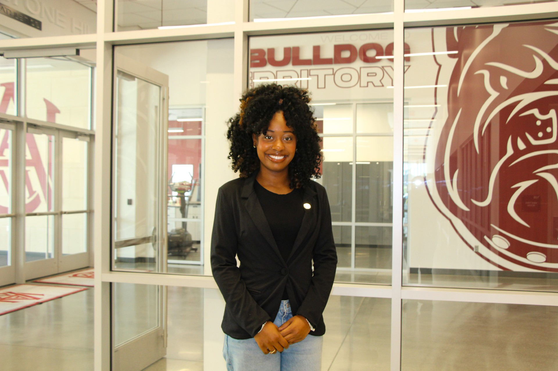 Current AAMU Junior Trinity Ferguson stands in front of Bulldog Territory in Event Center