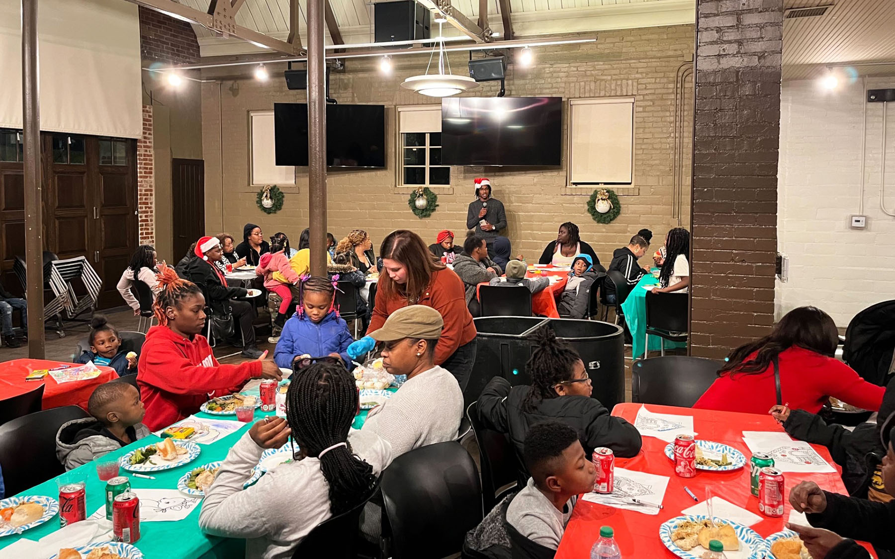 Alumnus and Eastern Toys founder Emondre Johnson speaks to families at last year's holiday event