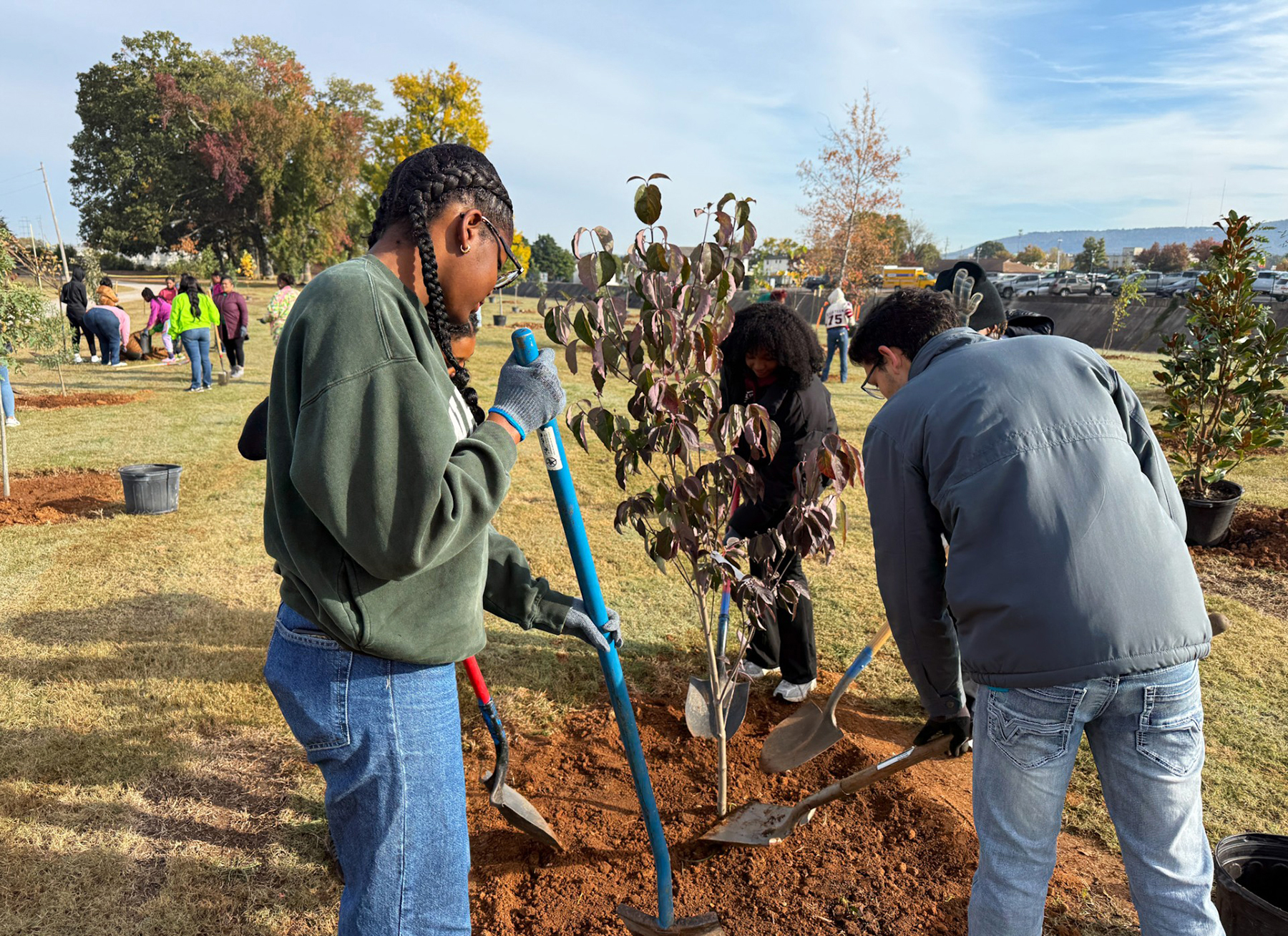 Three AAMU students plant a tree at Brahan Spring Park in Huntsville 