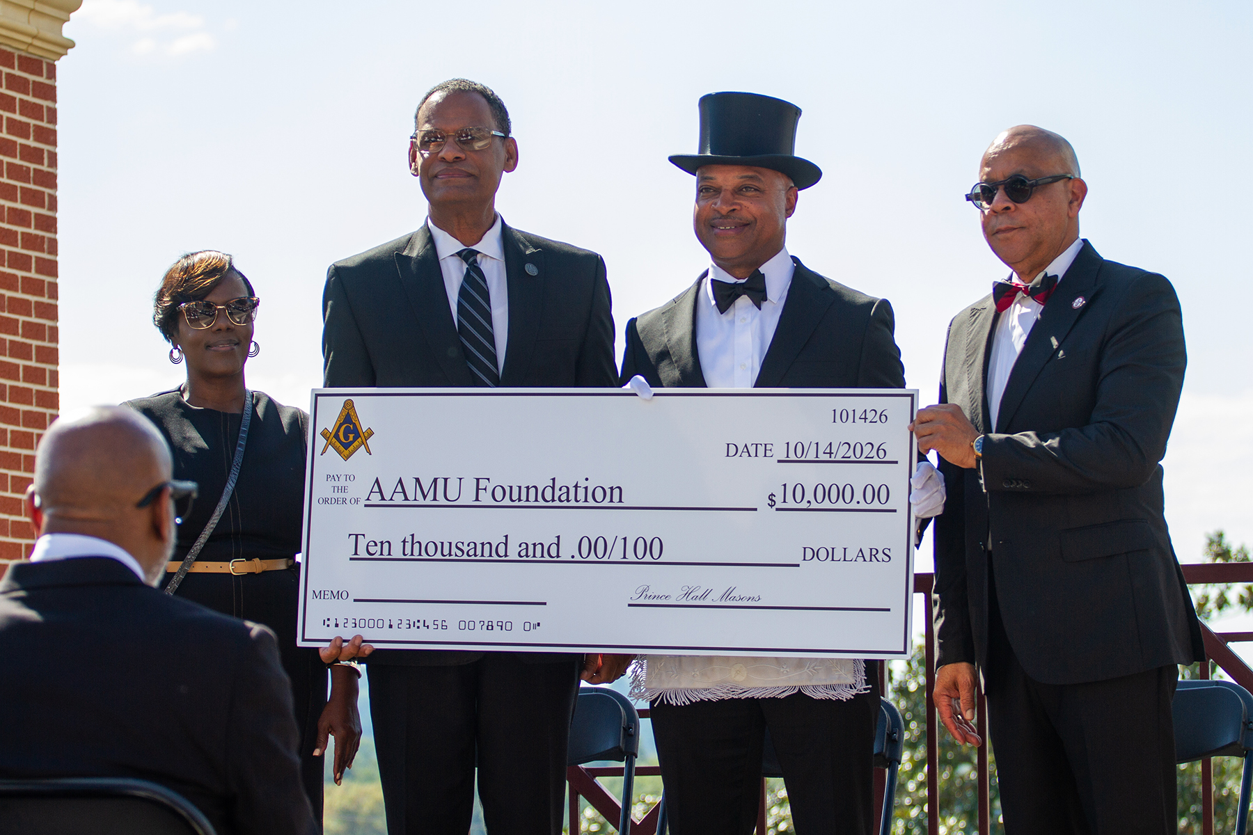 From left, Kim M. Davis, annual fund director; Alabama A&M University President Daniel K. Wims; Corey D. Hawkins Sr., grand master of the Prince Hall Grand Lodge of Alabama; and Jamal Ali, vice president for Marketing, Communication and Advancement, display a $10,000 scholarship contribution during the University's annual Homecoming wreath-laying ceremony Oct. 14, 2026.