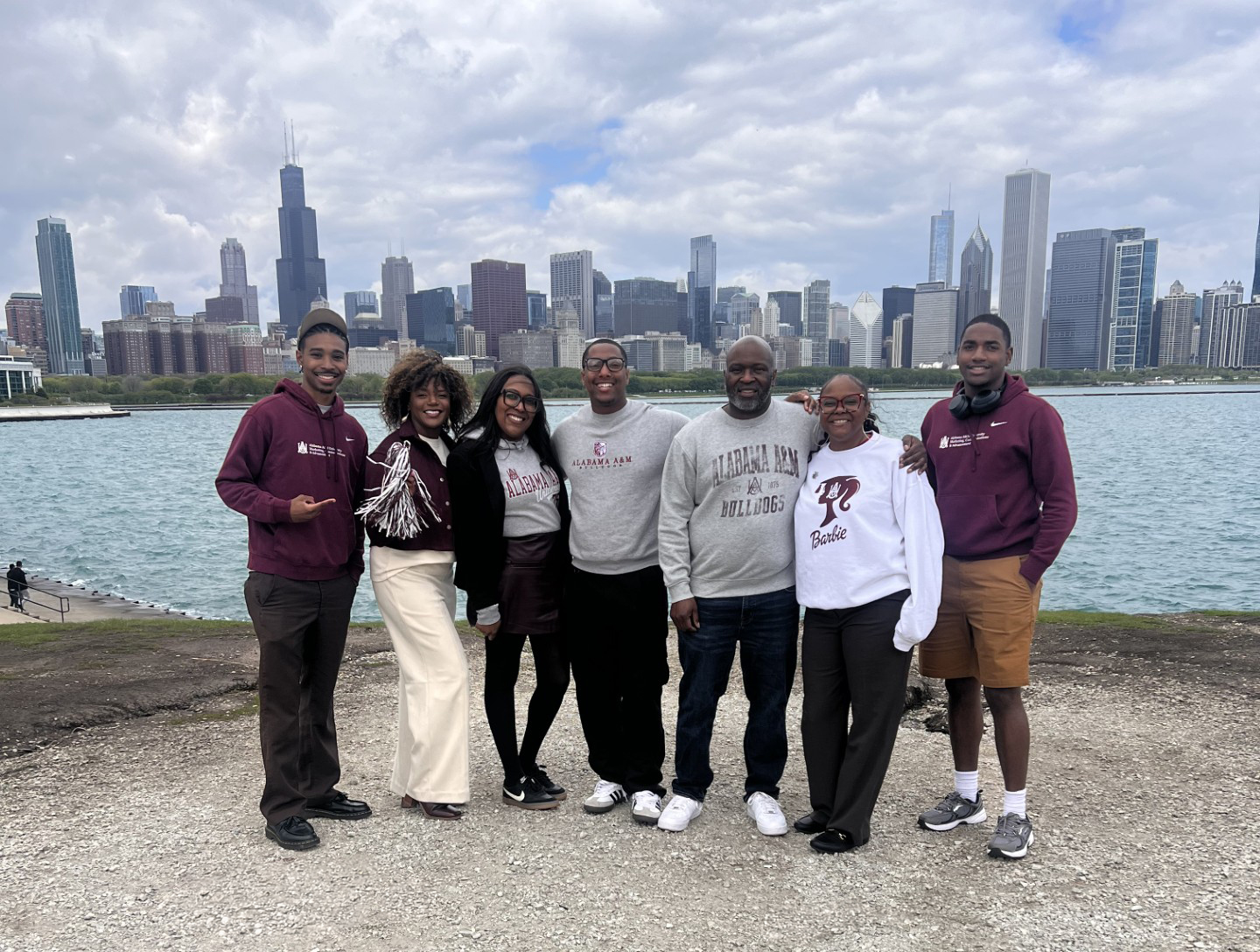 AAMU alumni smiling at Adler Planetarium with Chicago skyline behind them