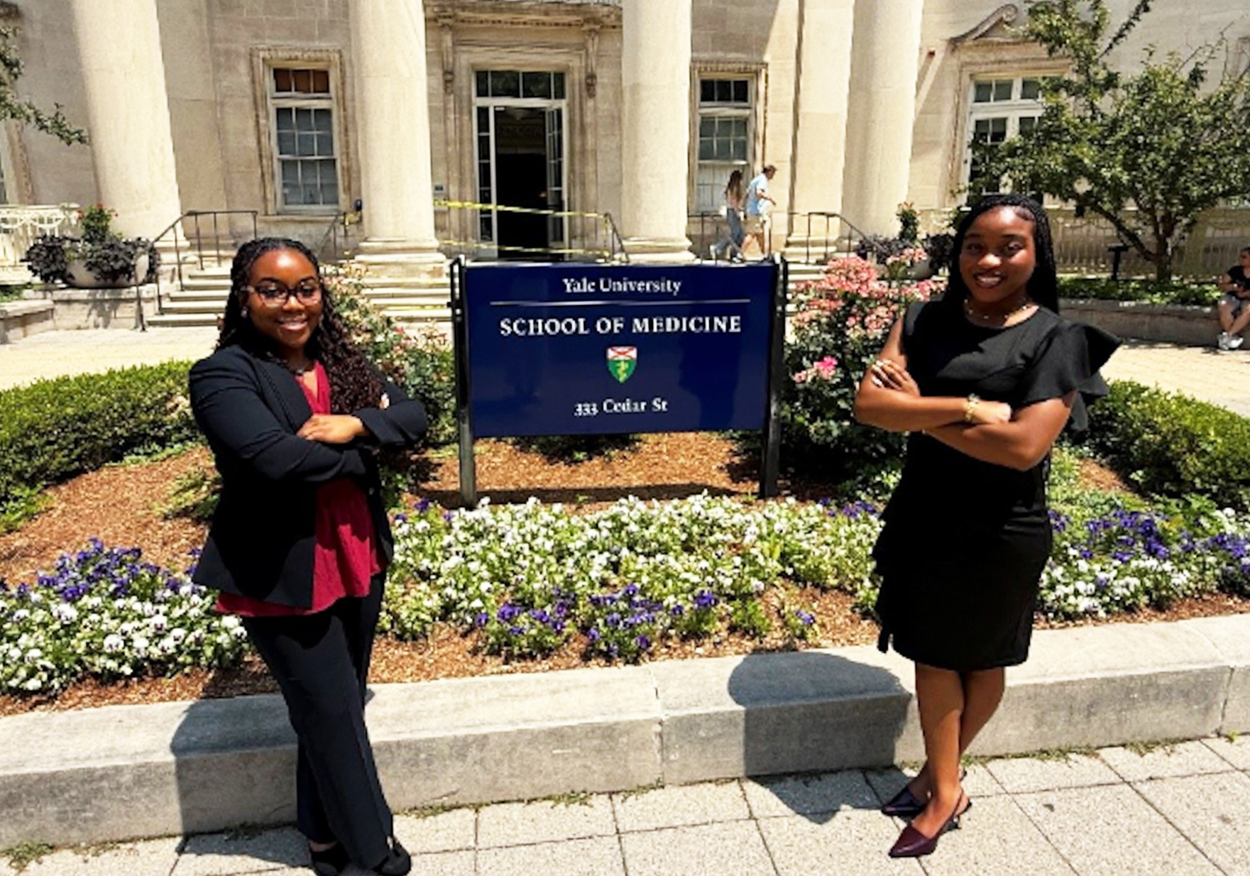 Dyleshia Bell and Lauren Pettus stand in front of the Yale University School Sign in New Haven, Conn.