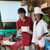 An agent stands with a youth participant after a cooking class.