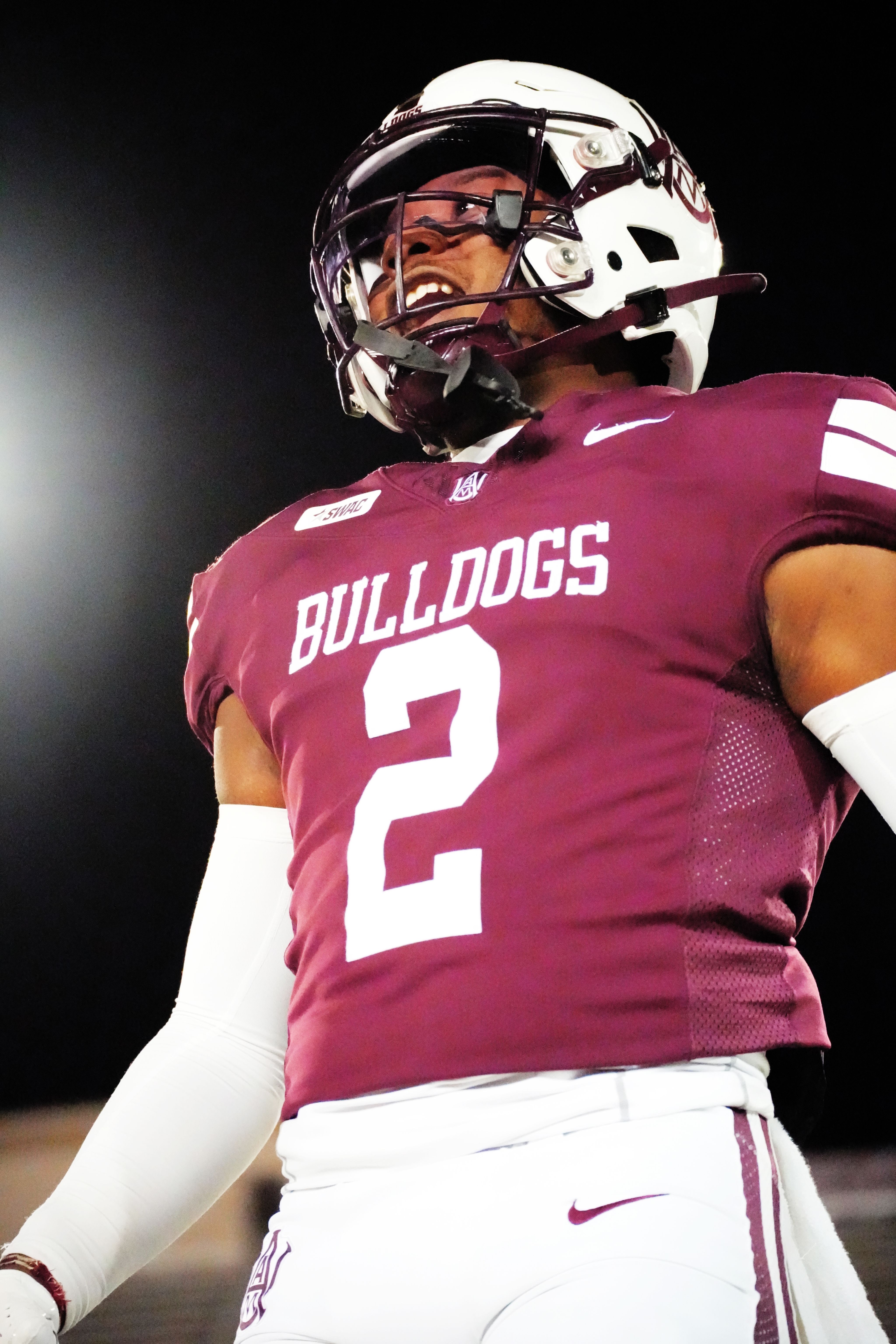 A Bulldog football player under the lights at a night game.