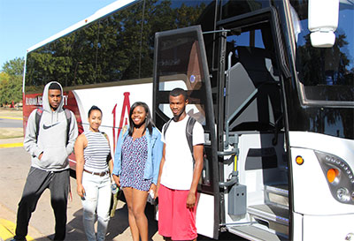 Students pose in front of a BTS bus