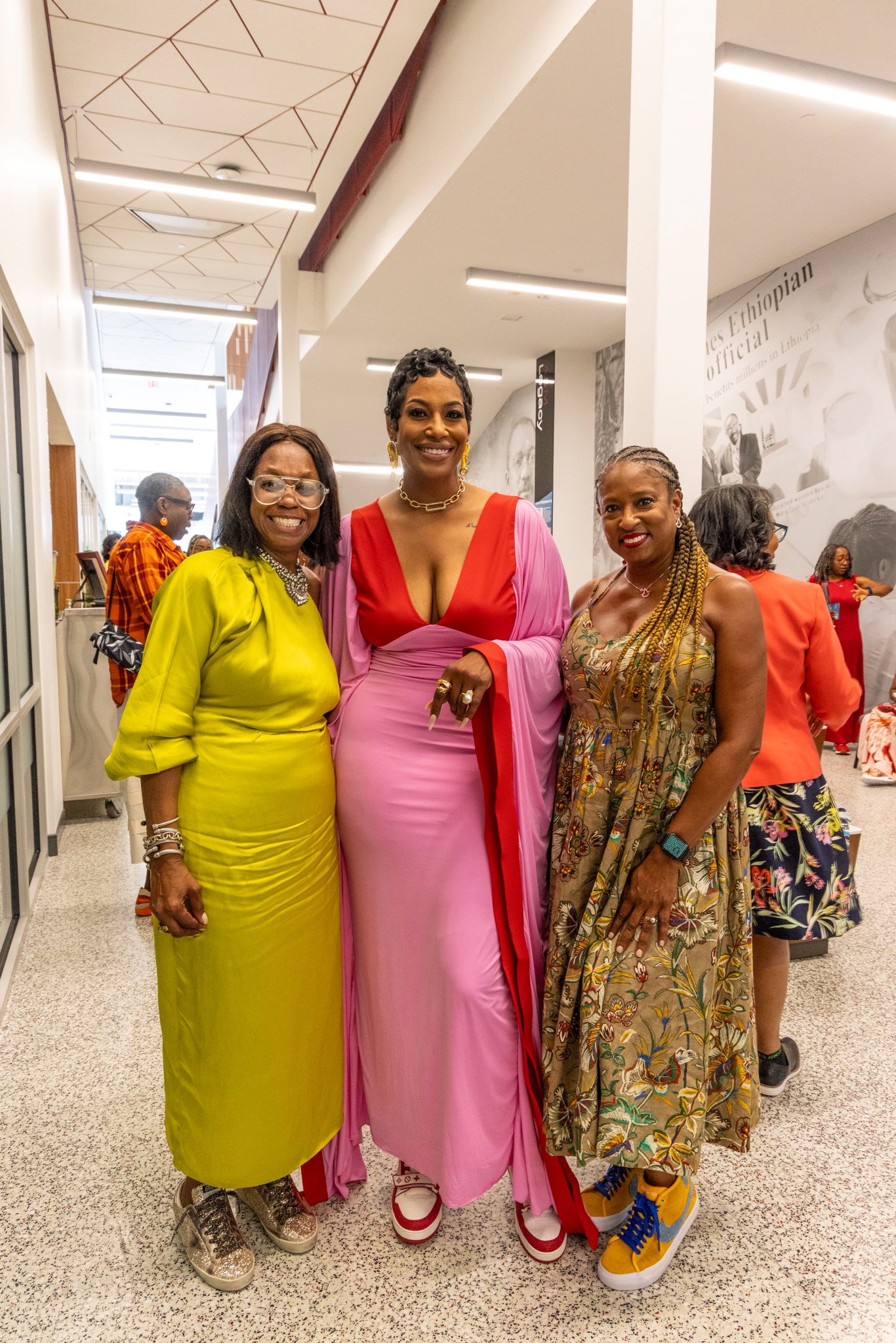 Coach Dawn Thornton smiles with two guests at the Sundresses & Sneakers Social