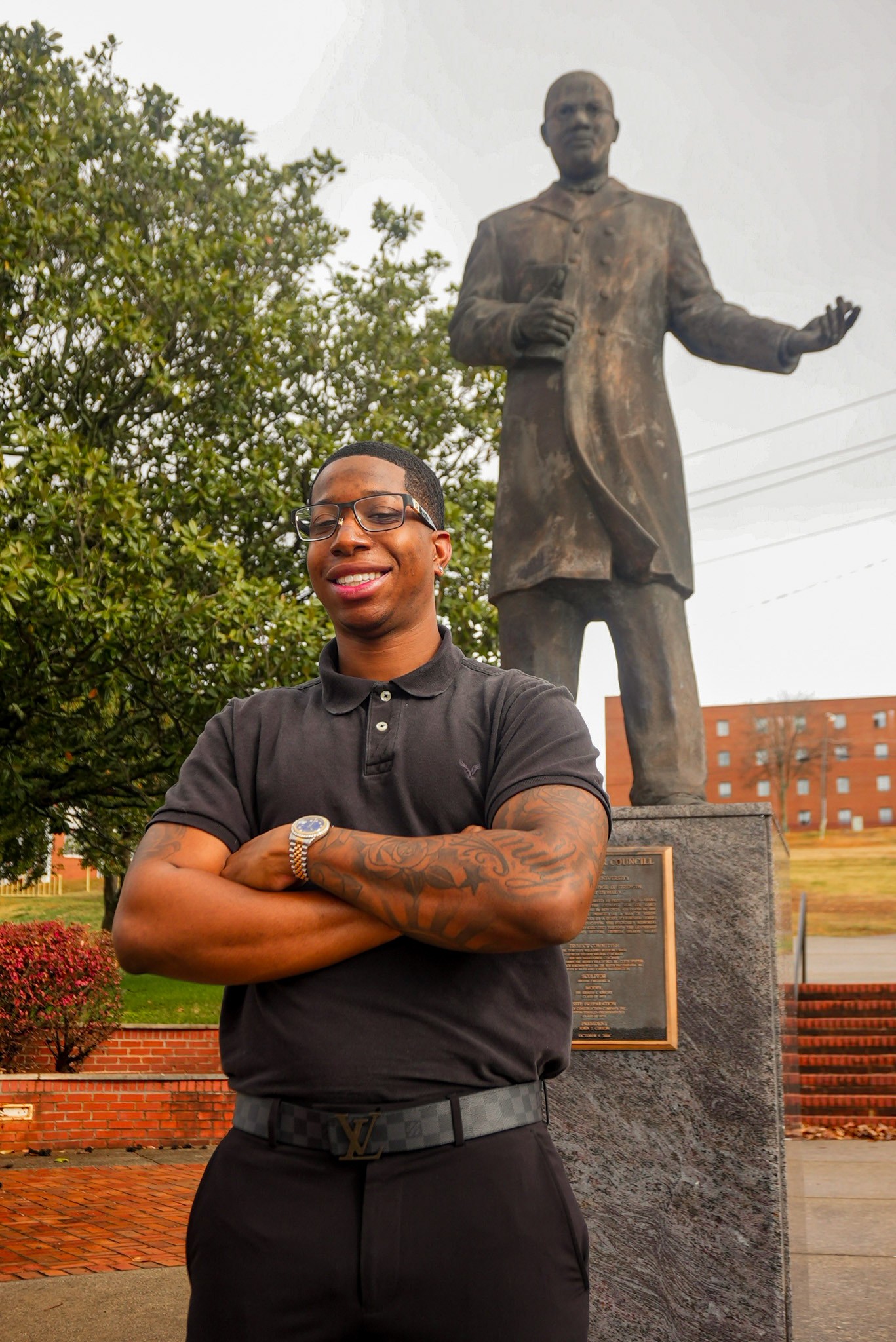 Mitchell Reed stands with arms crossed in fron the Dr. William Hooper Councill statue on campus