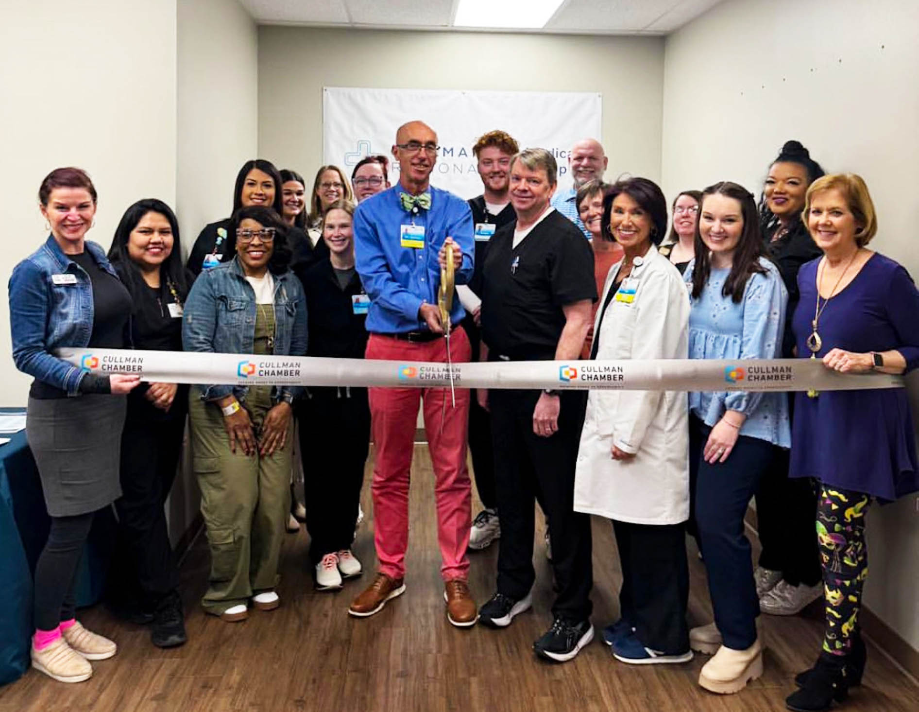 Byars poses with a group of people at a community ribbon cutting