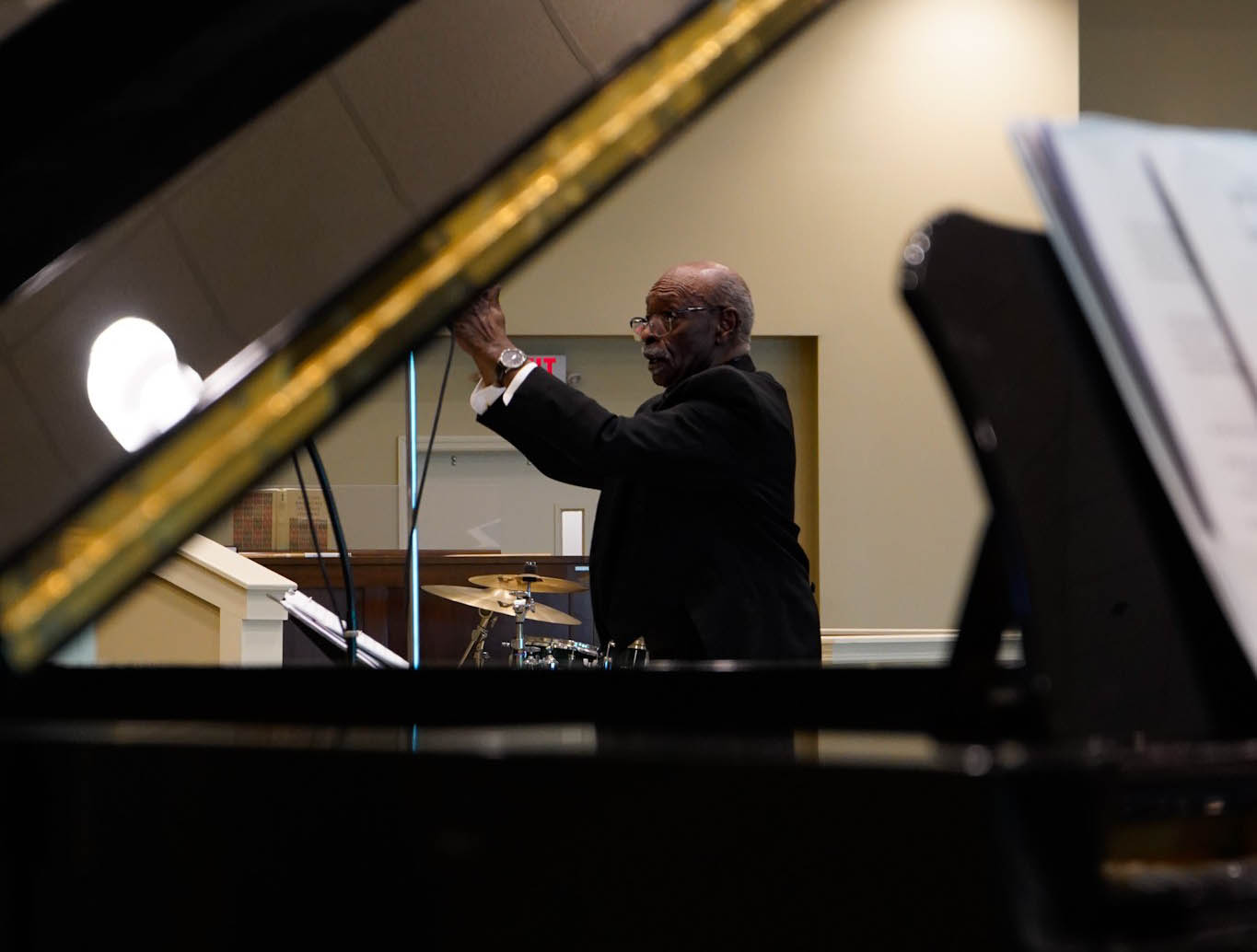 Dr. Carnery conducting and captured between piano base and lid