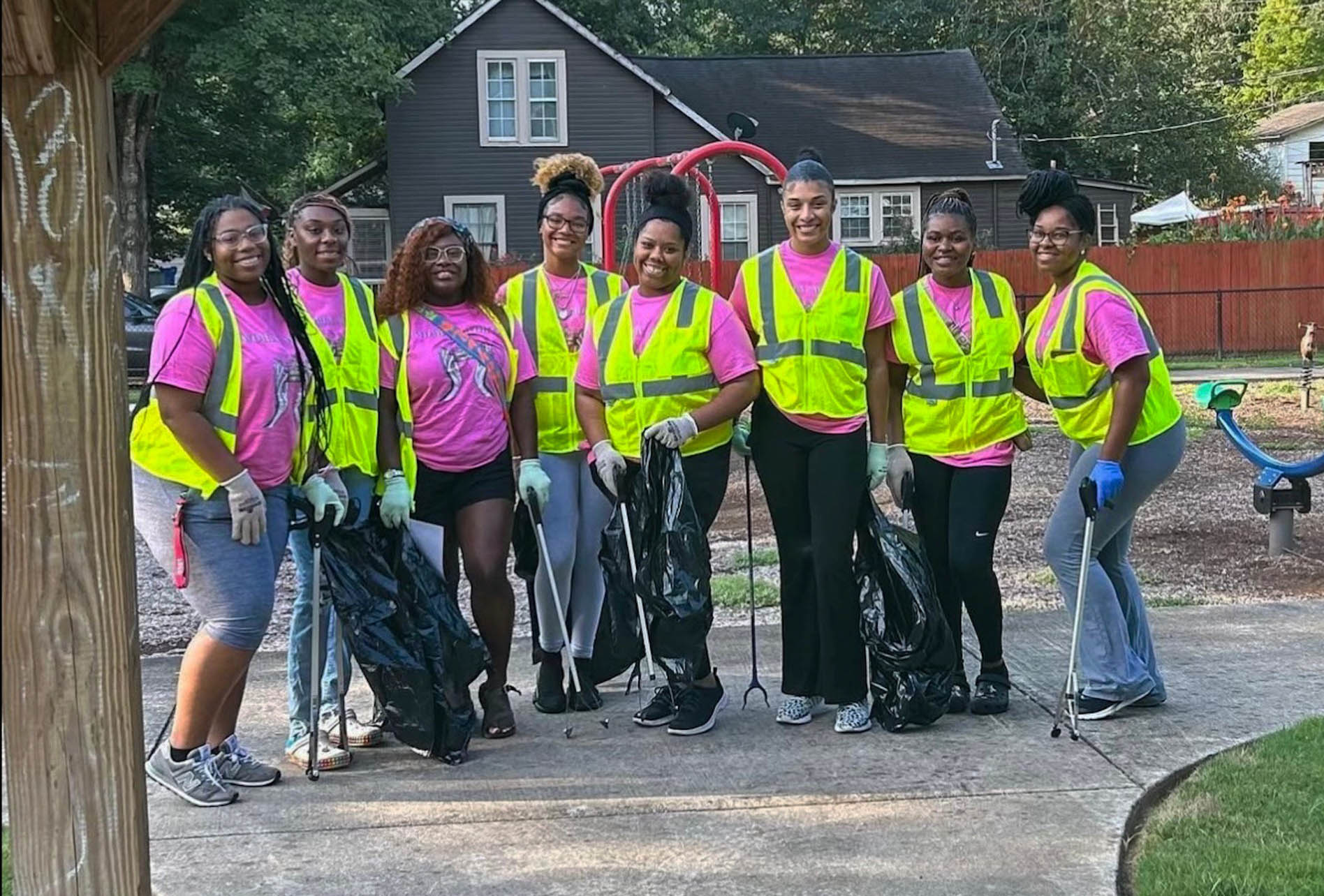 Farmer (fourth from the left) smiles with seven other students clearing trash on the AAMU campus