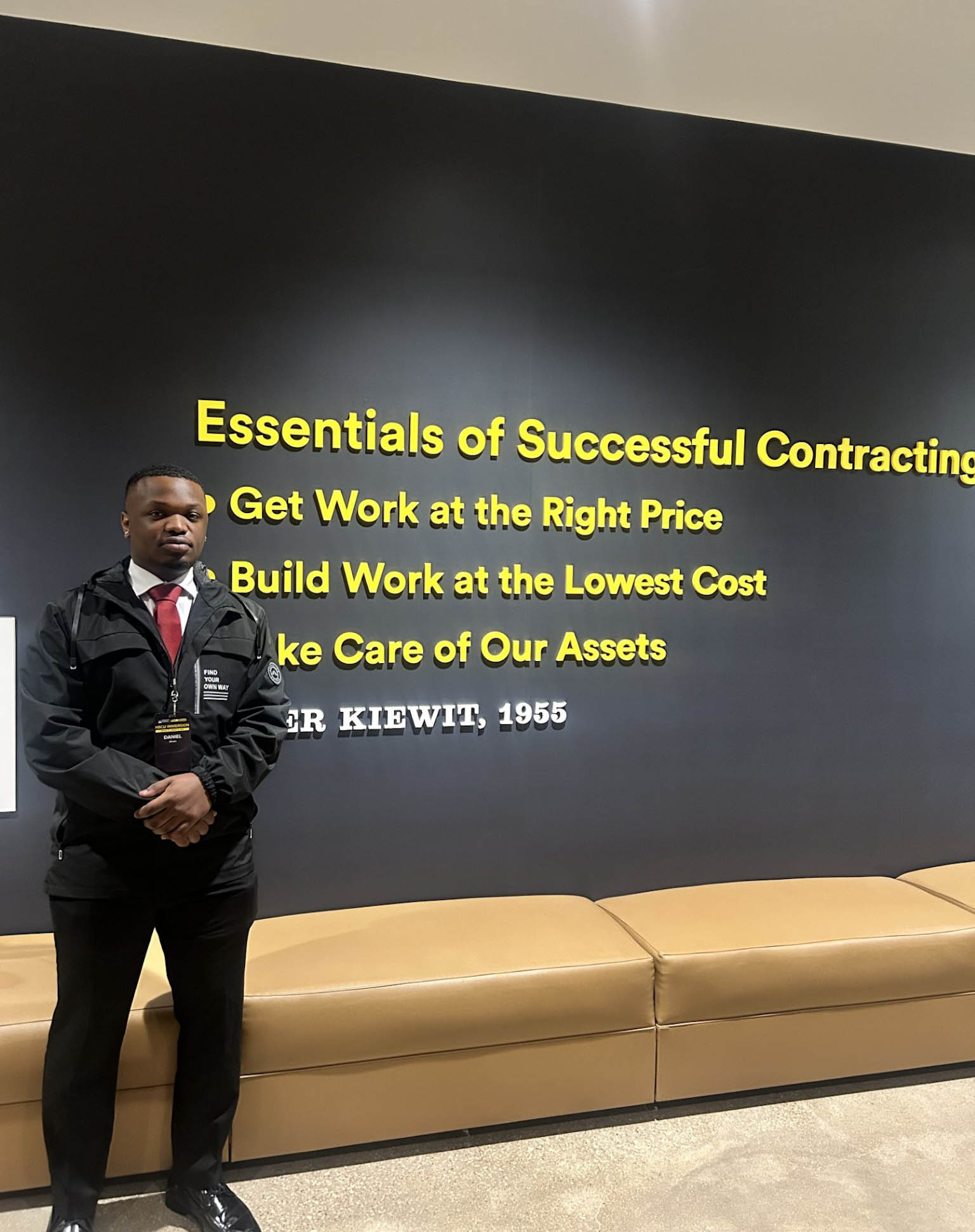 AAMU Senior Daniel Given Stands in front of Kiewit Corporation signage