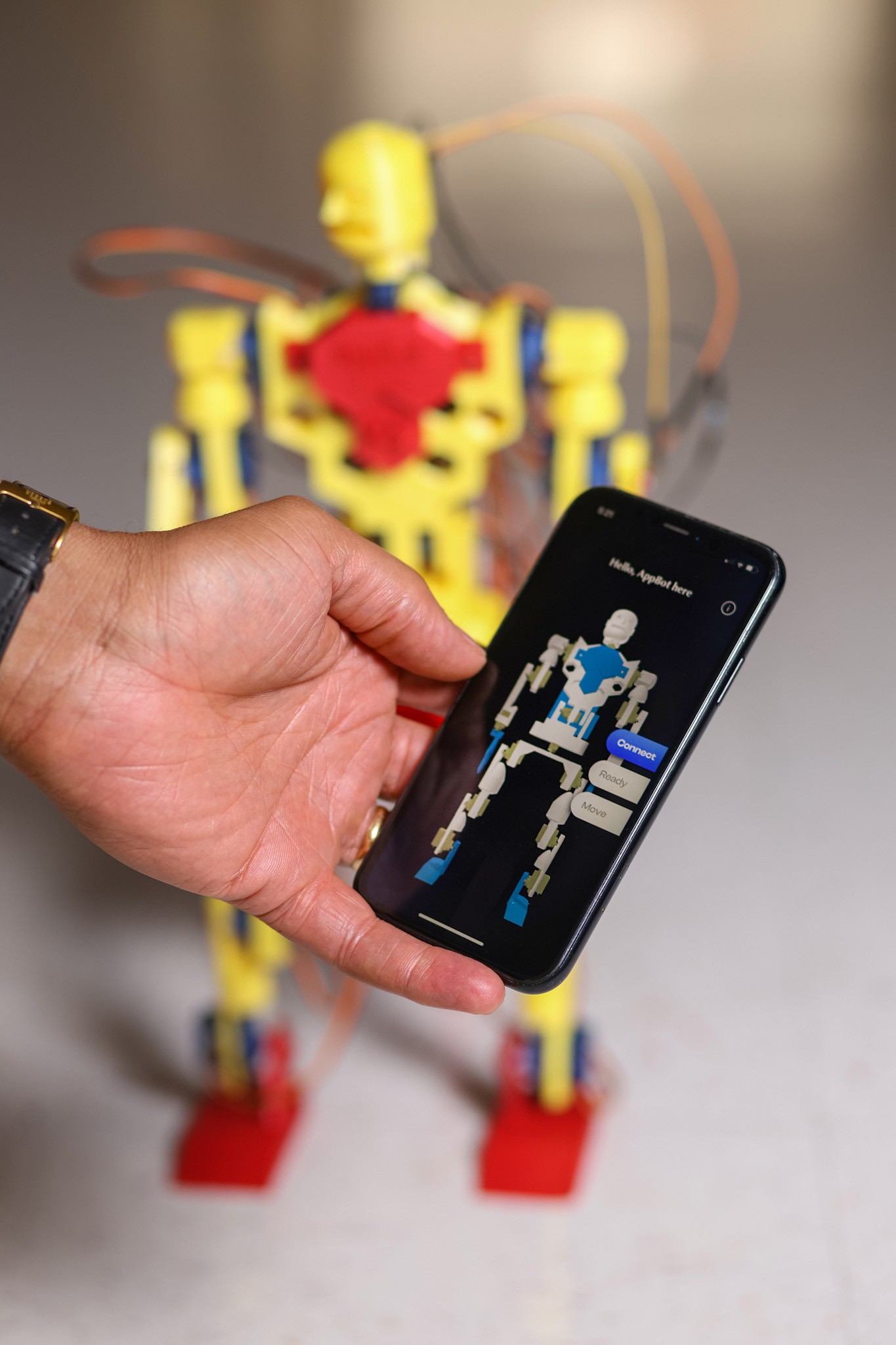 Glenn holds cellphone with AppBot app, with AppBot behind it