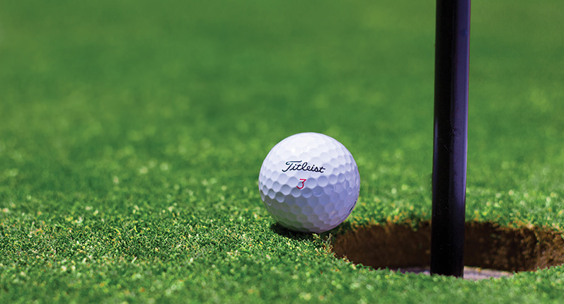 golf ball near pin in hole