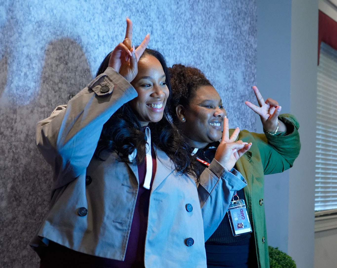 Two students show peace signs during photo at grad event