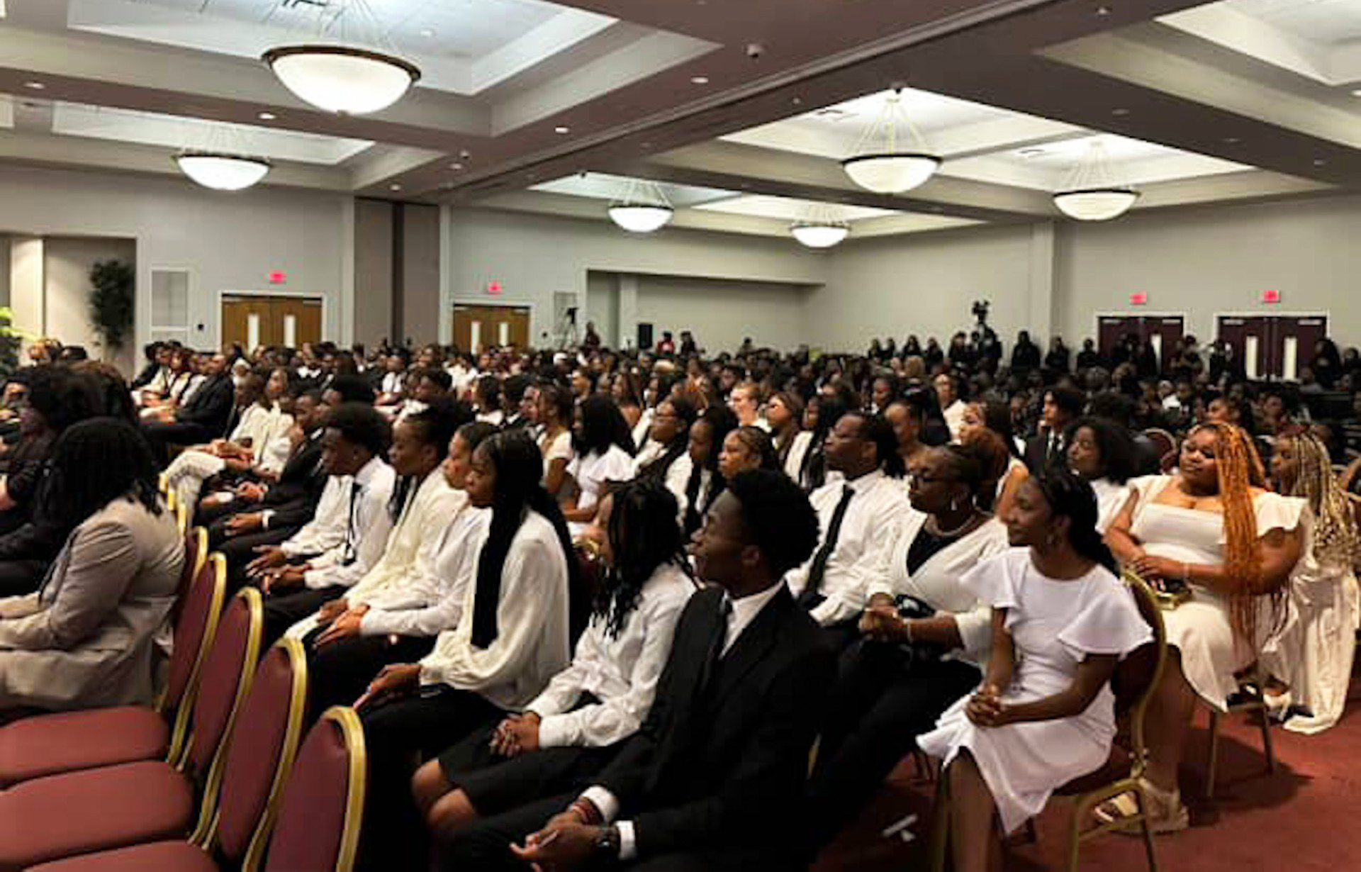Students seated holding candles at 2025-2026 Honors Program Induction August 29 at the Knight Center
