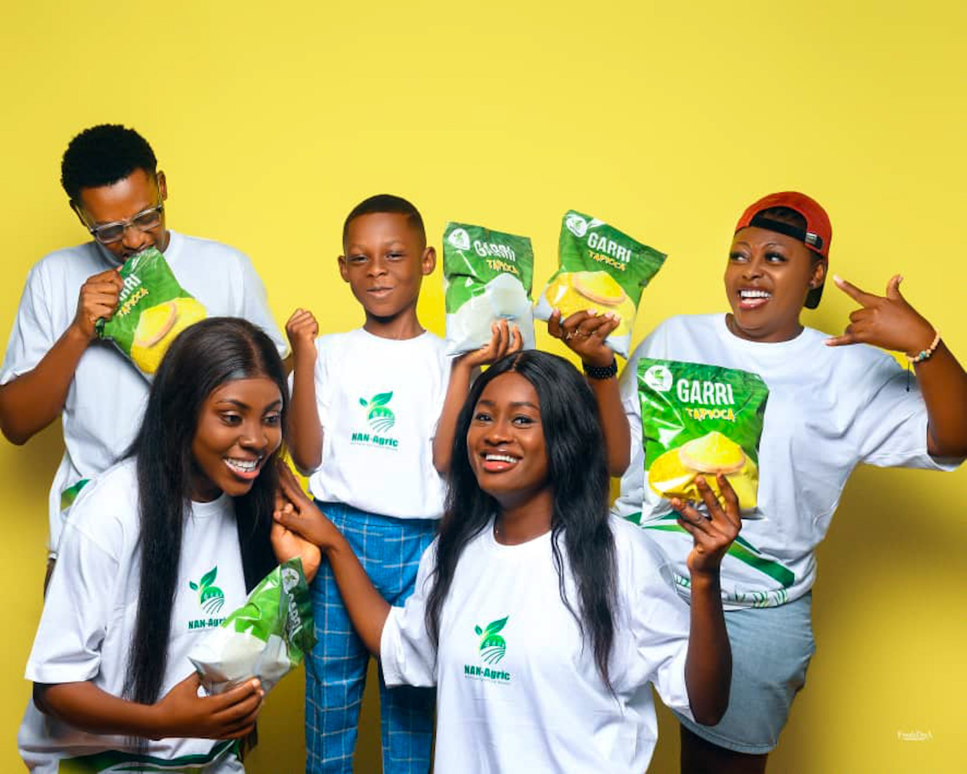Three women and two men animated and excited holding Garri Tapioca bags, a food product made from cassava
