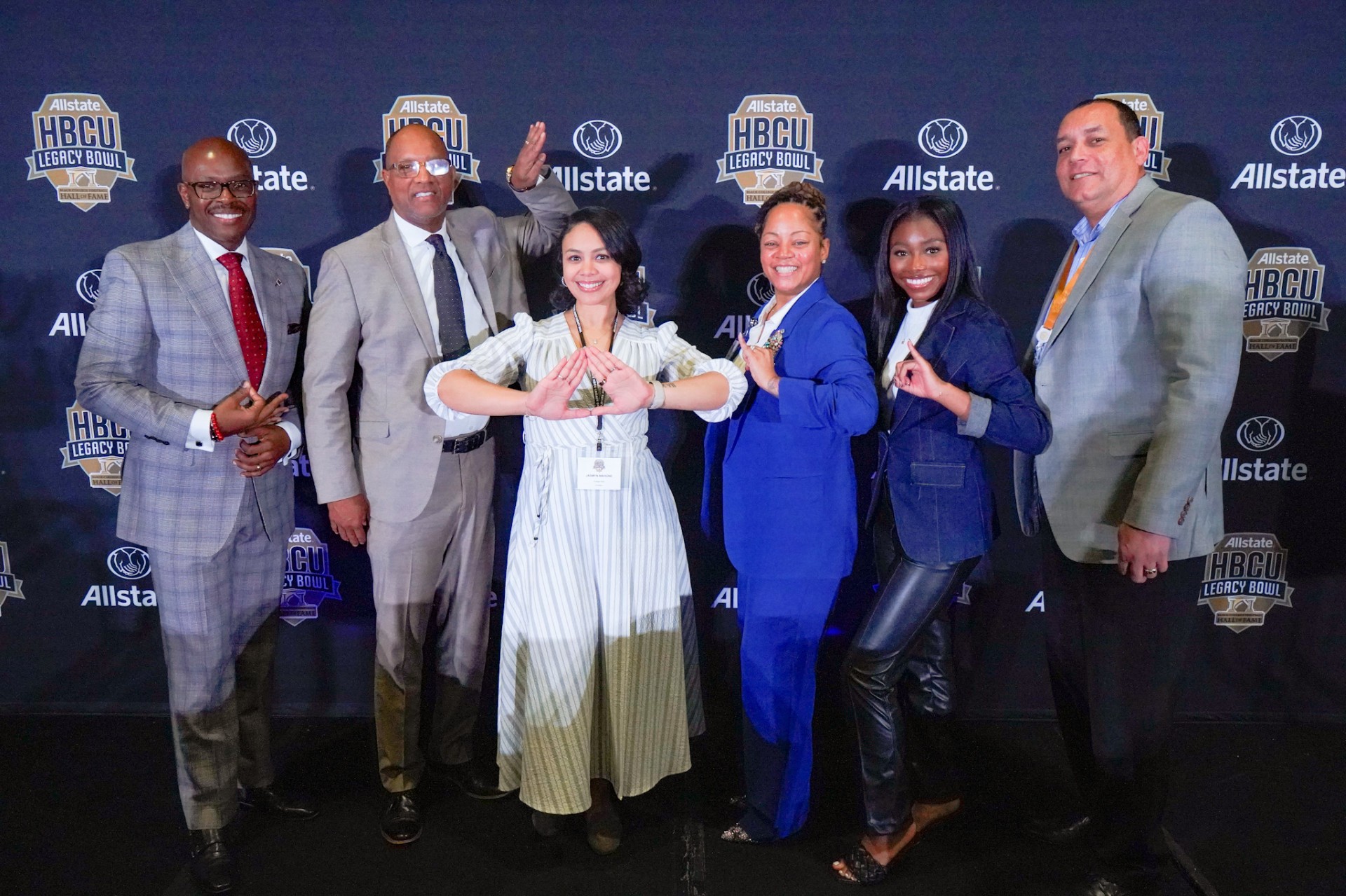 '91 Alumnus Dr. David Daniel (left) joins five other Career Fair Panelists, five showing Greek hand signs, as they smile informally after hosting the career fair.