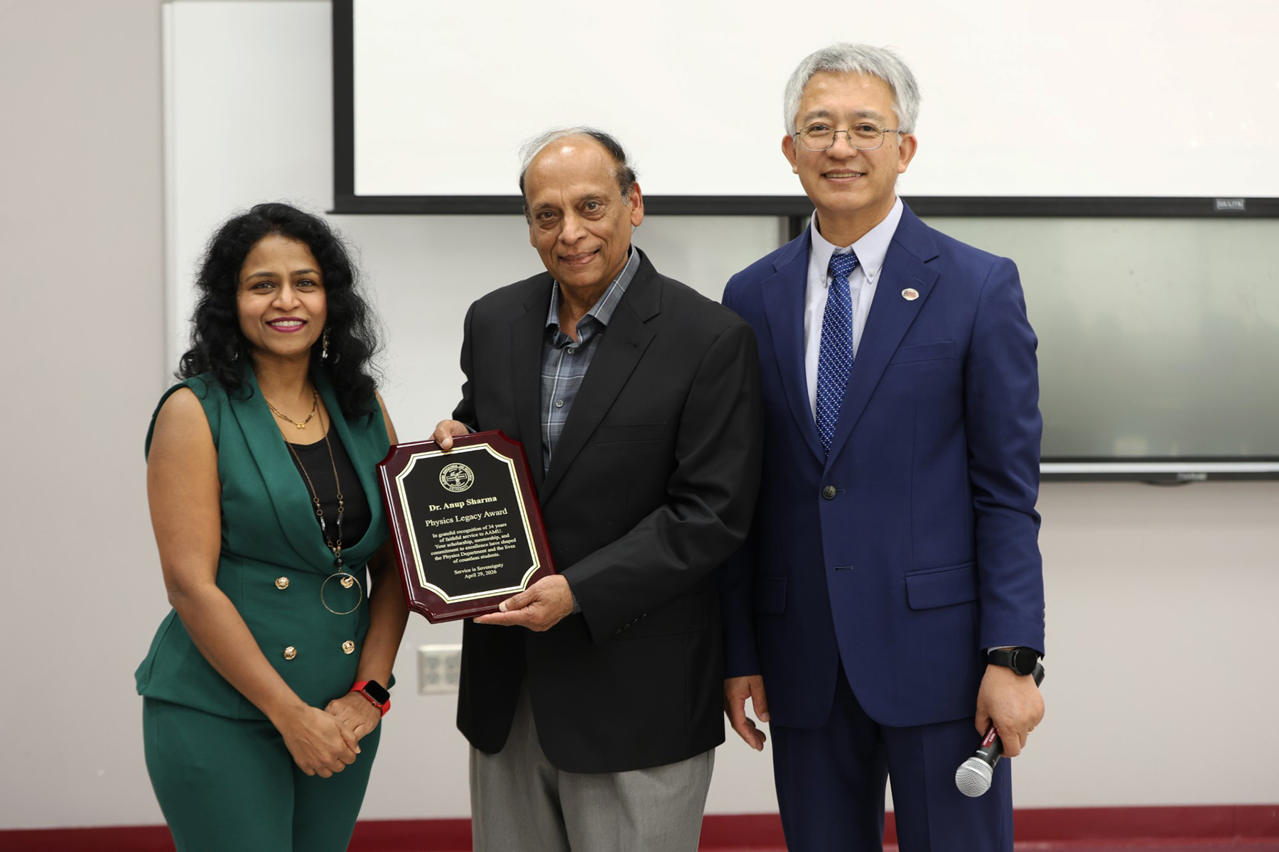 Anup Sharma, center, holds the Physics Legacy Award he received during his retirement celebration with Padmaja Guggilla, left, and ZT Deng.
