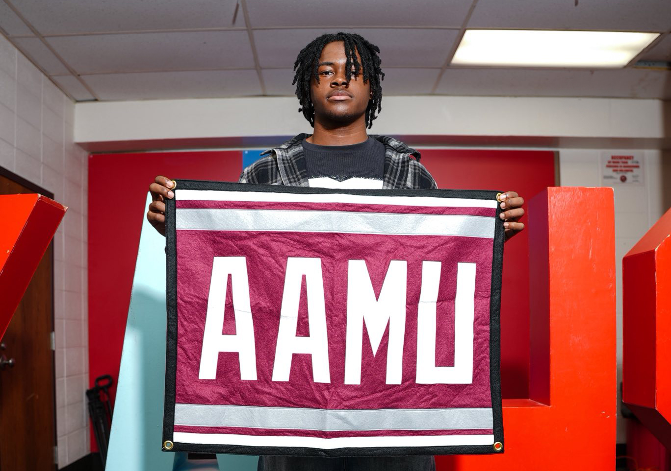 Jayden Island Holds AAMU Flag in the King Room of Kendwood Academy High School in Chicago