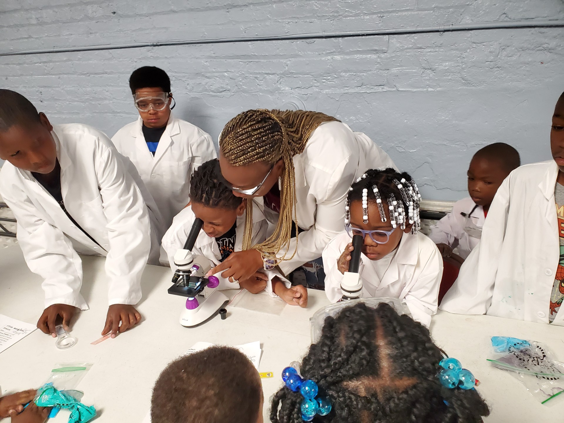 Osideko-Calloway oversees students looking into microscopes