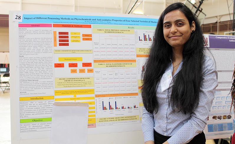 Stem Day student in front of presentation poster