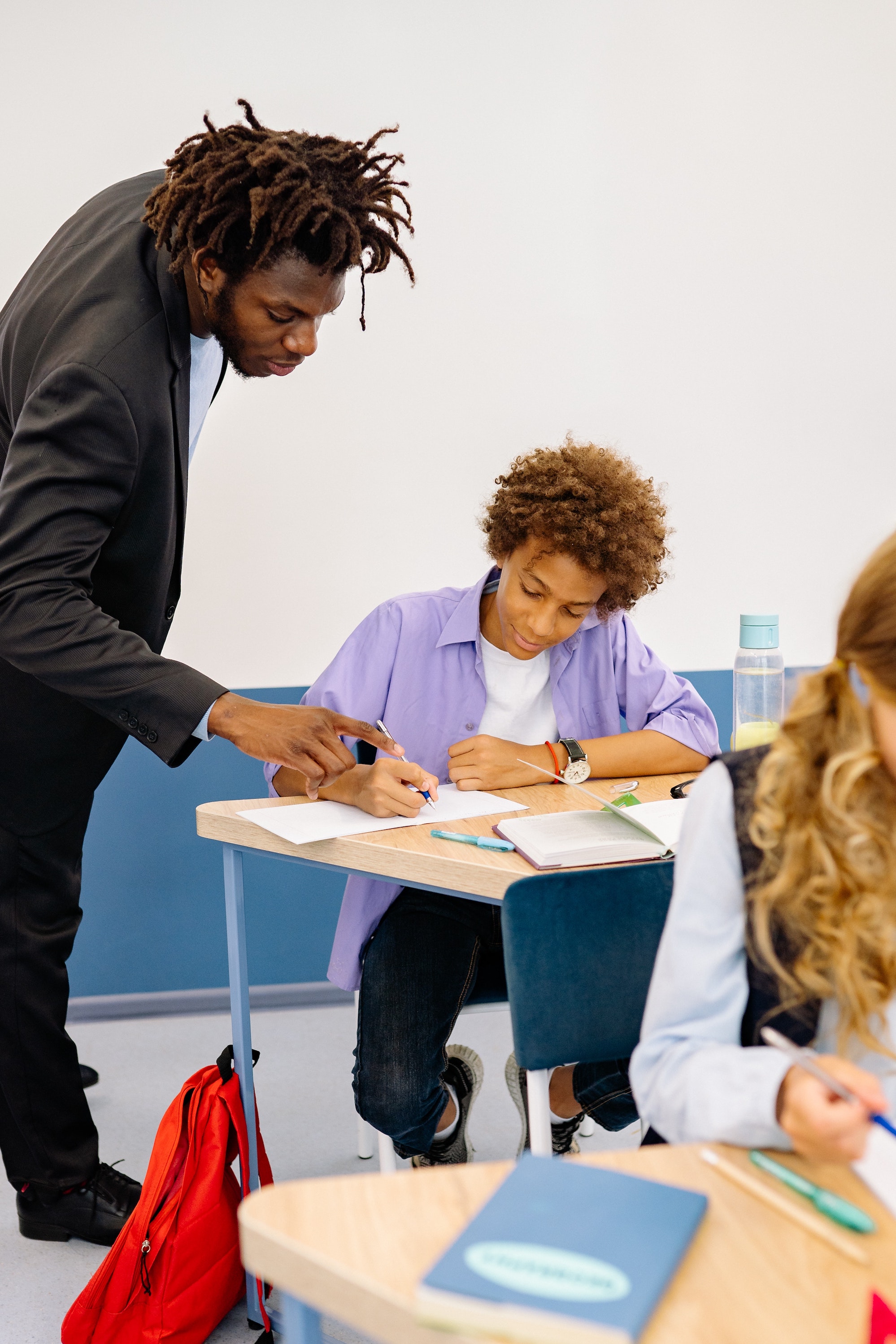 Black male teacher helping student