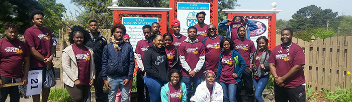 AAMU Student Volunteer's in front of Casa House sign