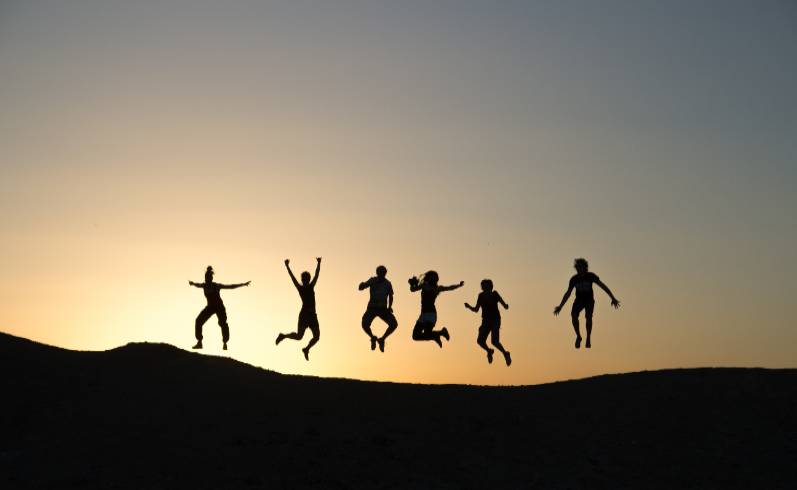 silhouettes of people jumping