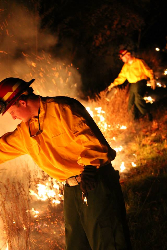 Two FireDawgs in front of a prescribed fire.